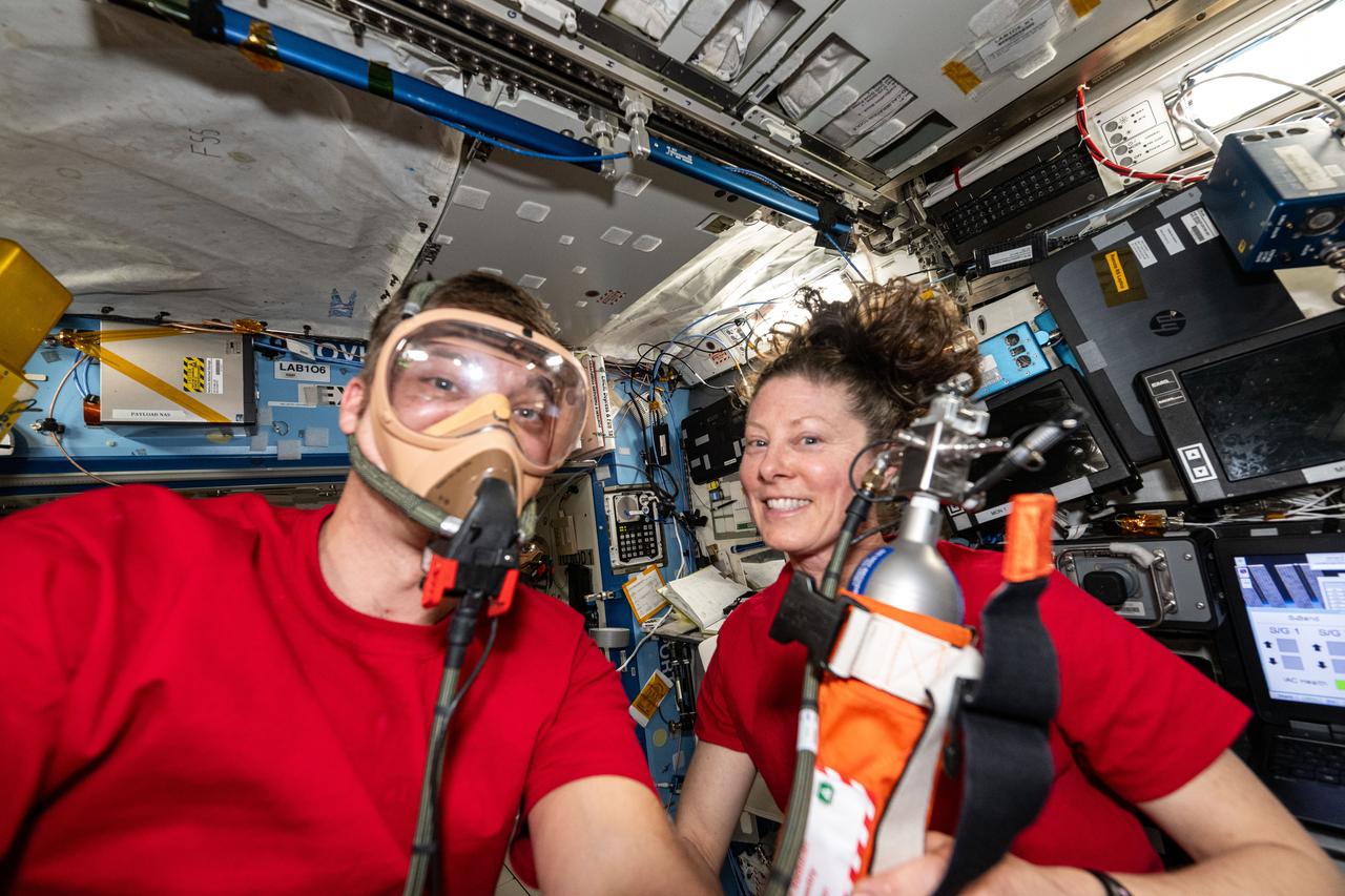 iss071e010040 (April 18, 2024) --- Expedition 71 Flight Engineers Matthew Dominick and Tracy C. Dyson, both NASA astronauts, pose for a fun portrait as Dominick tests portable breathing gear aboard the International Space Station's Destiny laboratory module.