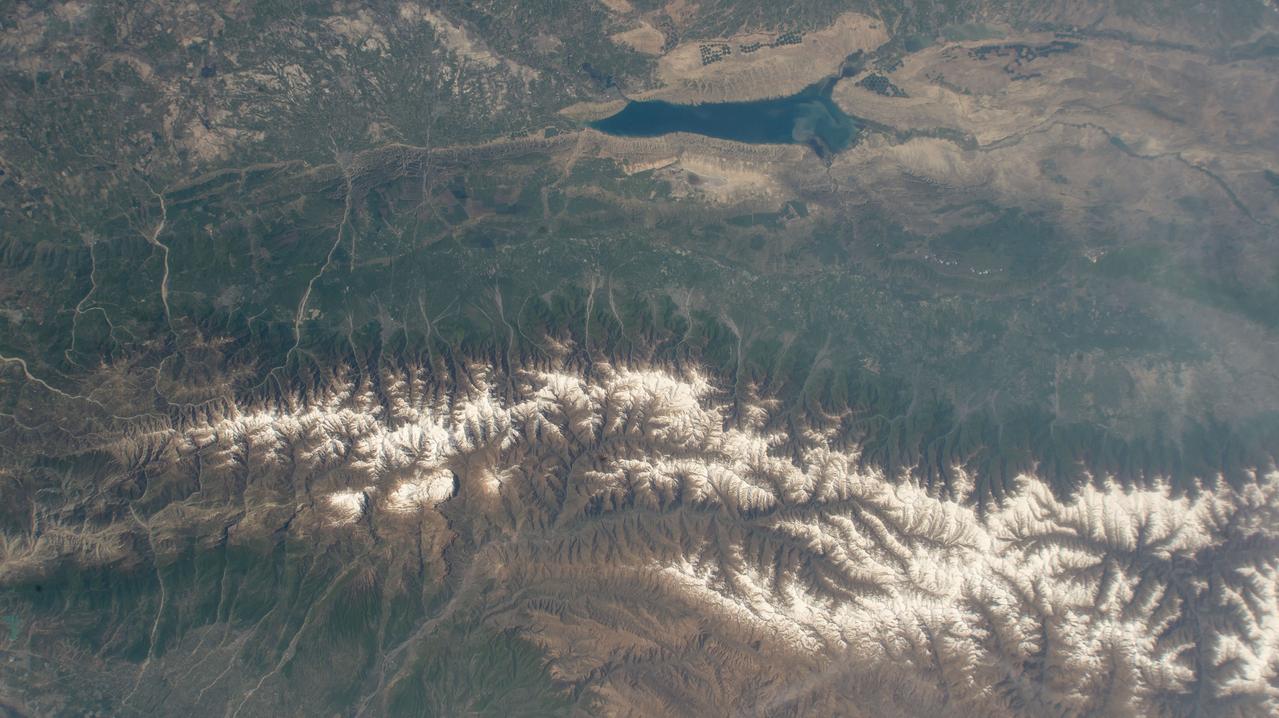 iss071e041651 (April 25, 2024) --- The snow-capped Caucasus Mountains run through Azerbaijan and Russia in this photograph from the International Space Station as it orbited 258 miles above. At top, is the Mingachevir Reservoir, the largest reservoir in the Caucasus and used for fishing, water supplies, and irrigation.