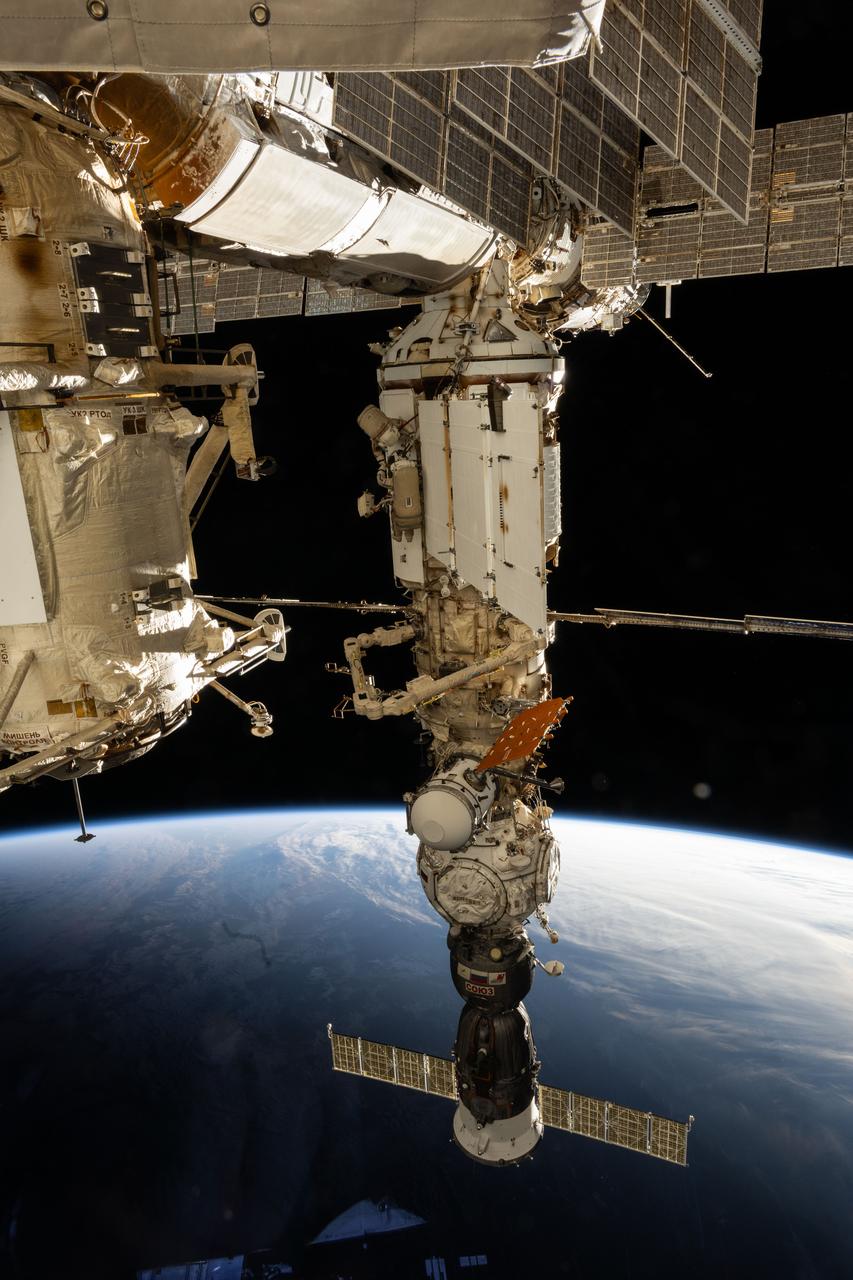 iss071e045543 (April 25, 2024) --- Cosmonauts (near center) Nikolai Chub and Oleg Kononenko are pictured outside of the International Space Station's Nauka science module wearing their Orlan spacesuits during a four-hour and 36-minute spacewalk. The spacewalkers worked on the Russian segment of the complex completing the deployment of one panel on a synthetic radar communications system. The duo also installed equipment and experiments to analyze the level of corrosion on station surfaces and modules. The space station was soaring into an orbital sunset 270 miles above the Indian Ocean south of Africa.