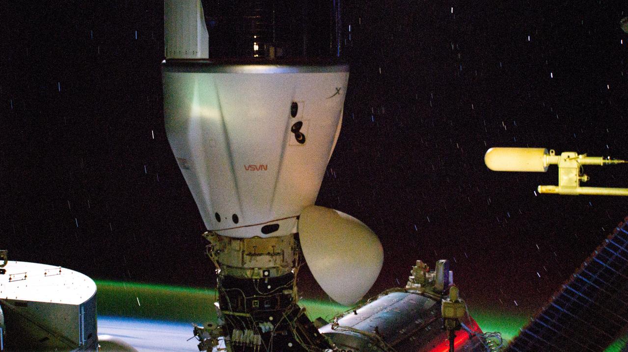 iss071e045750 (April 26, 2024) --- The SpaceX Dragon cargo spacecraft is pictured docked to the Harmony module's space-facing port on the International Space Station. In the background, slight star trails and an atmospheric glow above Earth's horizon are pictured in this long-duration photograph as the orbital outpost soared 267 miles above the Indian Ocean south of Africa.