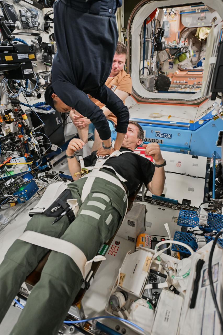 iss071e051133 (May 3, 2024) --- Flight Engineer Jeanette Epps practices cardiopulmonary resuscitation (CPR), or chest compressions, on Flight Engineer Mike Barratt, both NASA astronauts, as Roscosmos cosmonaut Alexander Grebenkin monitors. The trio reviewed medical procedures, hardware configurations, and commnication protocols in the unlikely event of an emergency aboard the International Space Station.