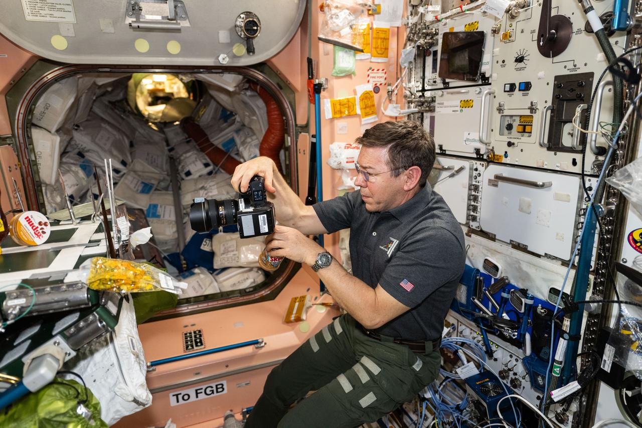 iss071e061169 (May 6, 2024) --- NASA astronaut and Expedition 71 Flight Engineer Mike Barratt photographs food packs in the Unity module's galley aboard the International Space Station.