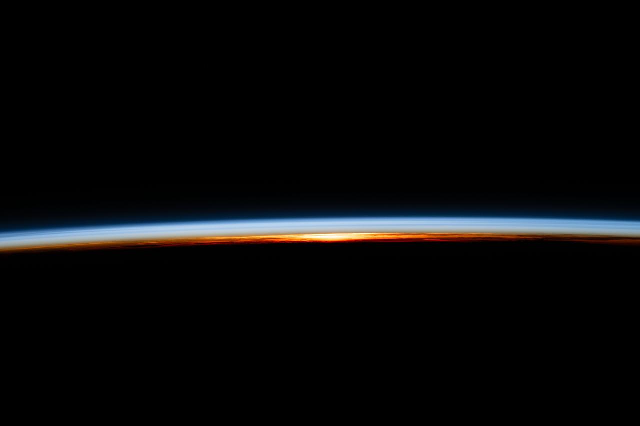 iss071e067117 (May 8, 2024) --- The last rays of an orbital sunset illuminate Earth's atmosphere and reveal the cloud tops in this photograph from the International Space Station as it orbited 258 miles above the Atlantic Ocean.