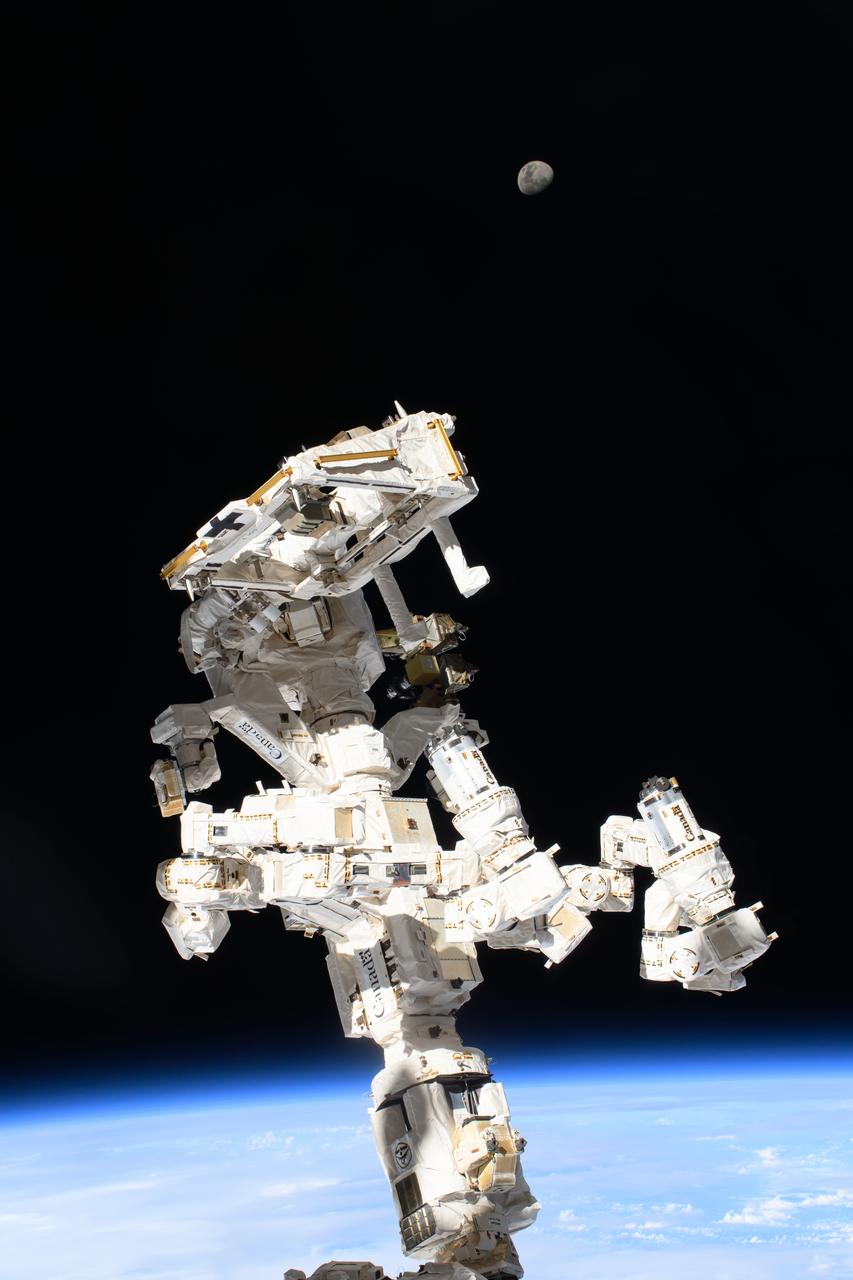 iss071e092171 (May 19, 2024) --- The International Space Station's Dextre, the fine-tuned robotic hand, attached to the Canadarm2 robotic arm dominates the frame with the waxing gibbous Moon (at top) in the background and the Indian Ocean 259 miles below.