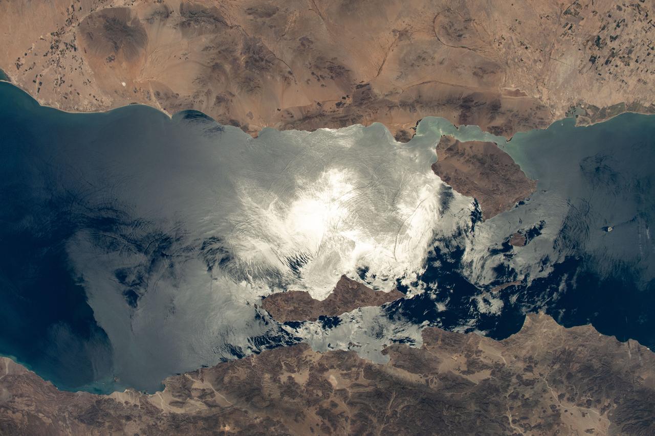 iss071e130631 (May 26, 2024) --- The sun's glint beams off the Gulf of California contrasting Mexico's coastal states of Baja California (bottom) and Sonora (top). In the middle of the frame (clockwise from top) are the islands of Tiburón, Turón, San Lorenzo, and Angel de la Guarda. The International Space Station was orbiting 261 miles above Sonora at the time of this photograph.