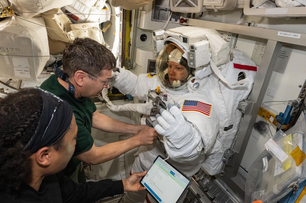 iss071e143649 (May 30, 2024) --- Expedition 71 Flight Engineers (from left) Jeanette Epps and Matthew Dominick assist Expedition 71 Flight Engineer Tracy C. Dyson, all three NASA astronauts, during a spacesuit fit check inside the International Space Station's Quest airlock.