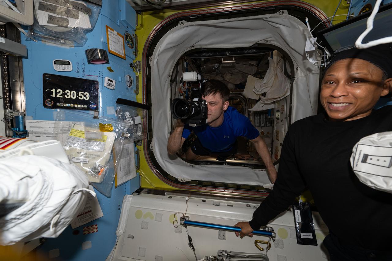 iss071e143785 (May 30, 2024) --- Expedition 71 Flight Engineer Matthew Dominick photographs activities in the International Space Station's Quest airlock as Expedition 71 Flight Engineer Jeanette Epps looks on. Dominick and Epps are both NASA astronauts on their first long-term space mission.