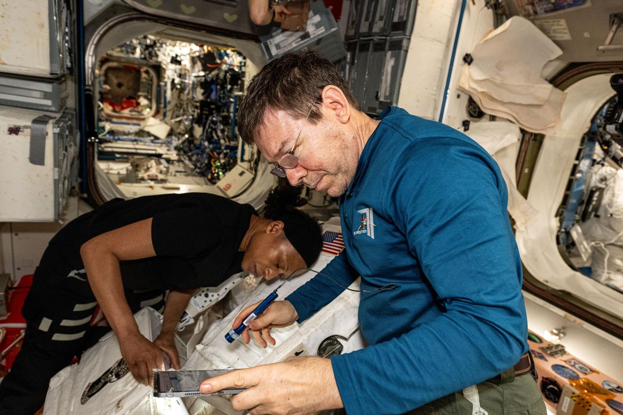 iss071e160383 (June 3, 2024) --- Expedition 71 Flight Engineers Jeanette Epps and Mike Barratt, both NASA astronauts, practice installing safety components on a spacesuit inside the International Space Station's Unity moduile.