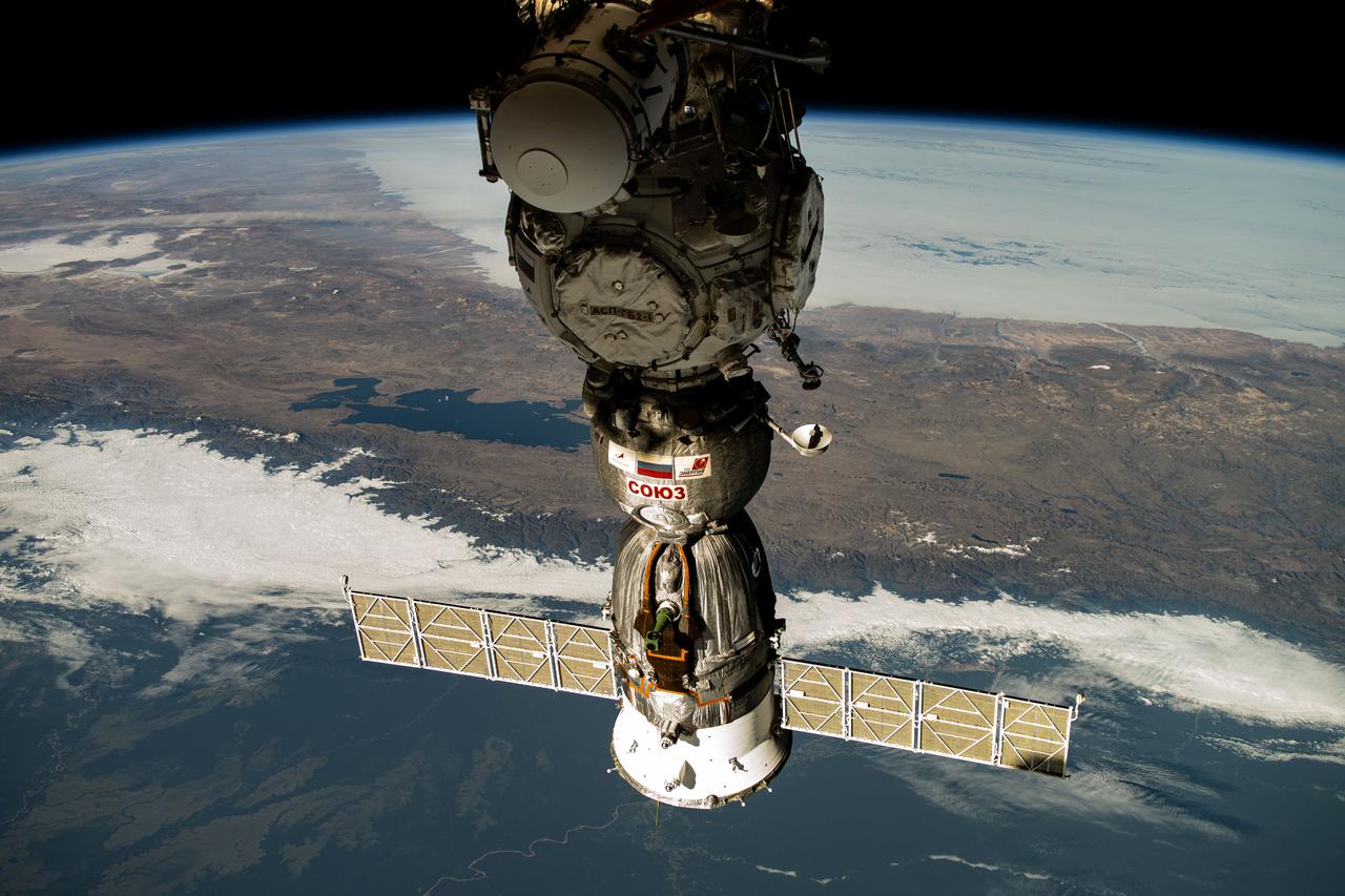 iss071e163005 (June 3, 2024) --- The Soyuz MS-25 crew ship is pictured docked to the Prichal docking module as the International Space Station orbited 258 miles above South America. Highlights in the background of this photograph include Lake Titicaca and the snow-capped Andes mountiain range.