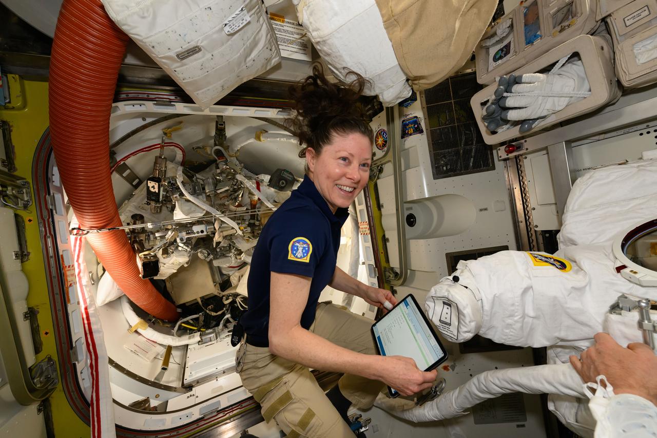 iss071e178113 (June 5, 2024) --- NASA astronaut and Expedition 71 Flight Engineer Tracy C. Dyson works inside the International Space Station's Quest airlock and checks procedures on a computer tablet to prepare a spacesuit for a fit verification.