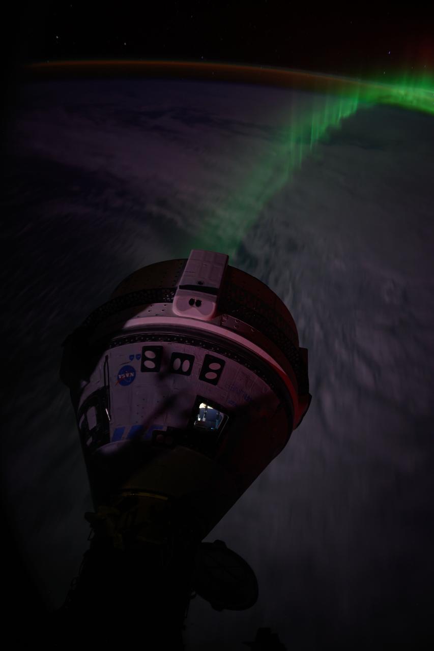 iss071e185130 (June 15, 2024) --- An aurora streams below Boeing's Starliner spacecraft docked to the forward port on the Harmony module as the International Space Station soared 266 miles above the Indian Ocean southwest of Australia.