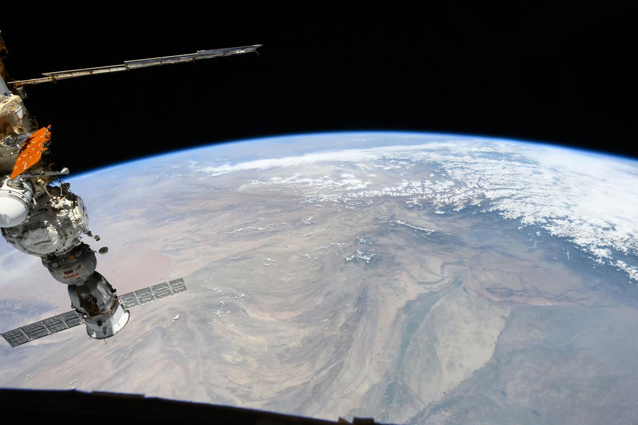 iss071e207474 (June 24, 2024) --- The snow-covered Himalayas separate the Indian sub-continent from China in this photograph from the International Space Station as it orbited 264 miles above. At left, is the Soyuz MS-25 crew ship docked to the Prichal docking module.