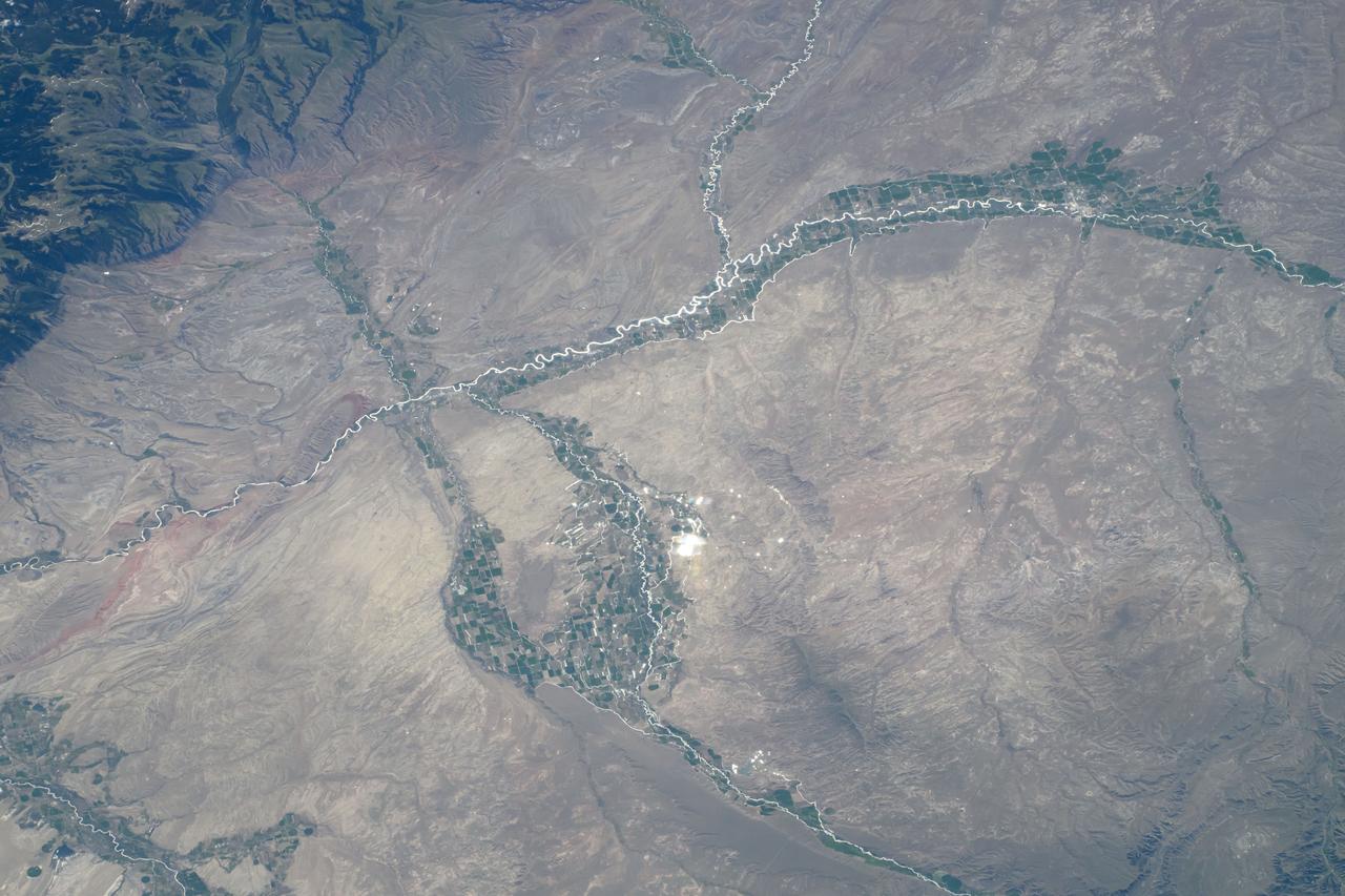 iss071e216801 (June 25, 2024) --- Towns and farmland along the Bighorn River and near the Bighorn National Forest (upper left) in Wyoming are pictured from the International Space Station as it orbited 264 miles above.