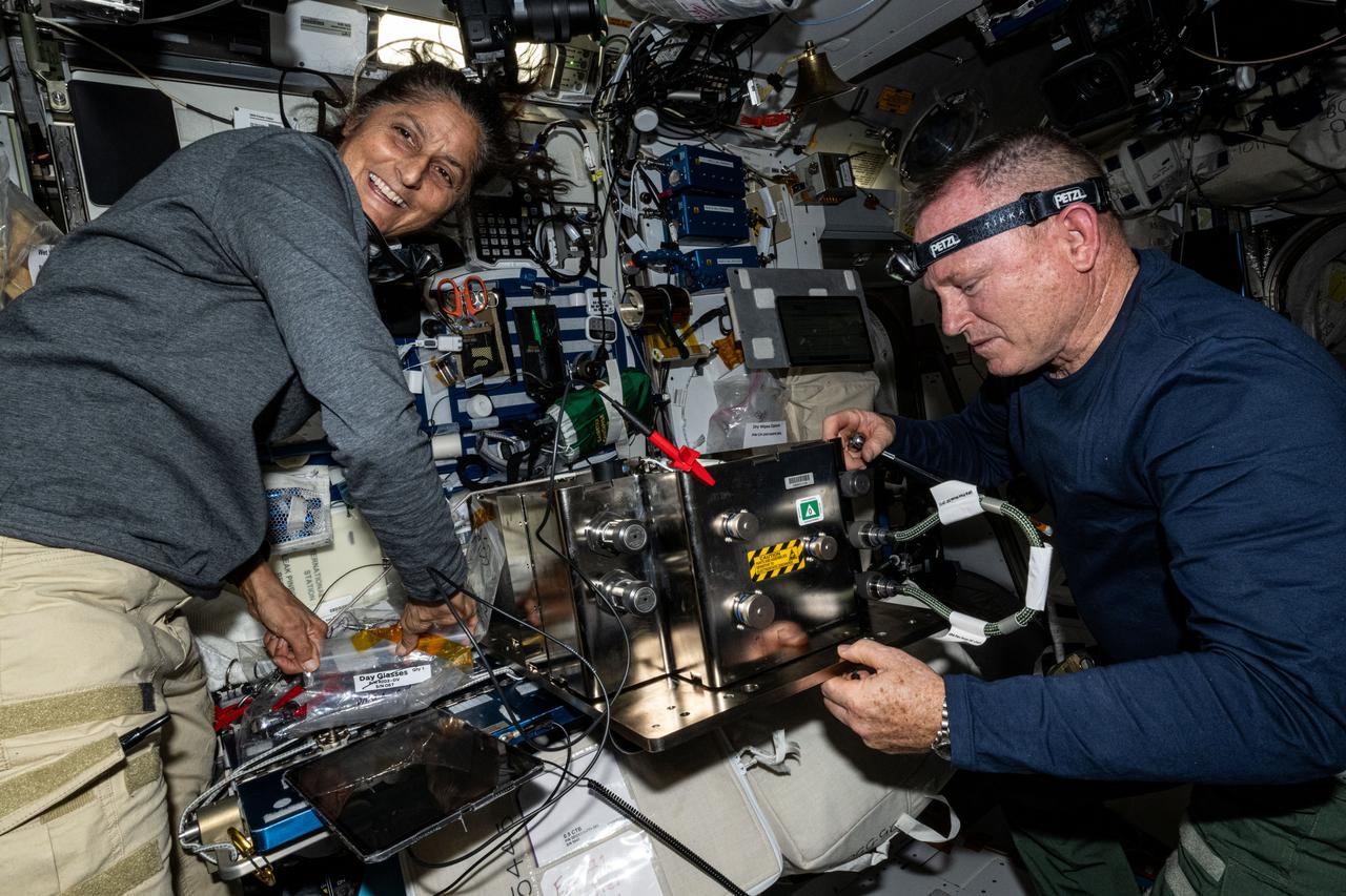 iss071e230838 (June 27, 2024) --- NASA's Boeing Crew Flight Test astronauts Suni Williams and Butch Wilmore prepare orbital plumbing hardware for installation inside the International Space Station’s bathroom, also known as the waste and hygiene compartment, located in the Tranquility module.