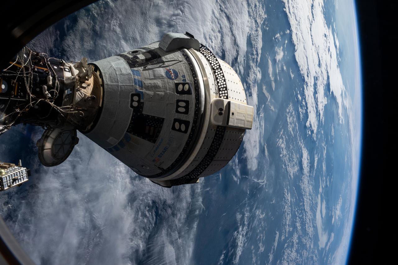 iss071e265103 (July 3, 2024) --- Boeing's Starliner spacecraft that launched NASA's Crew Flight Test astronauts Butch Wilmore and Suni Williams to the International Space Station is pictured docked to the Harmony module's forward port. This view is from a window on the SpaceX Dragon Endeavour spacecraft docked to the port adjacent to the Starliner.