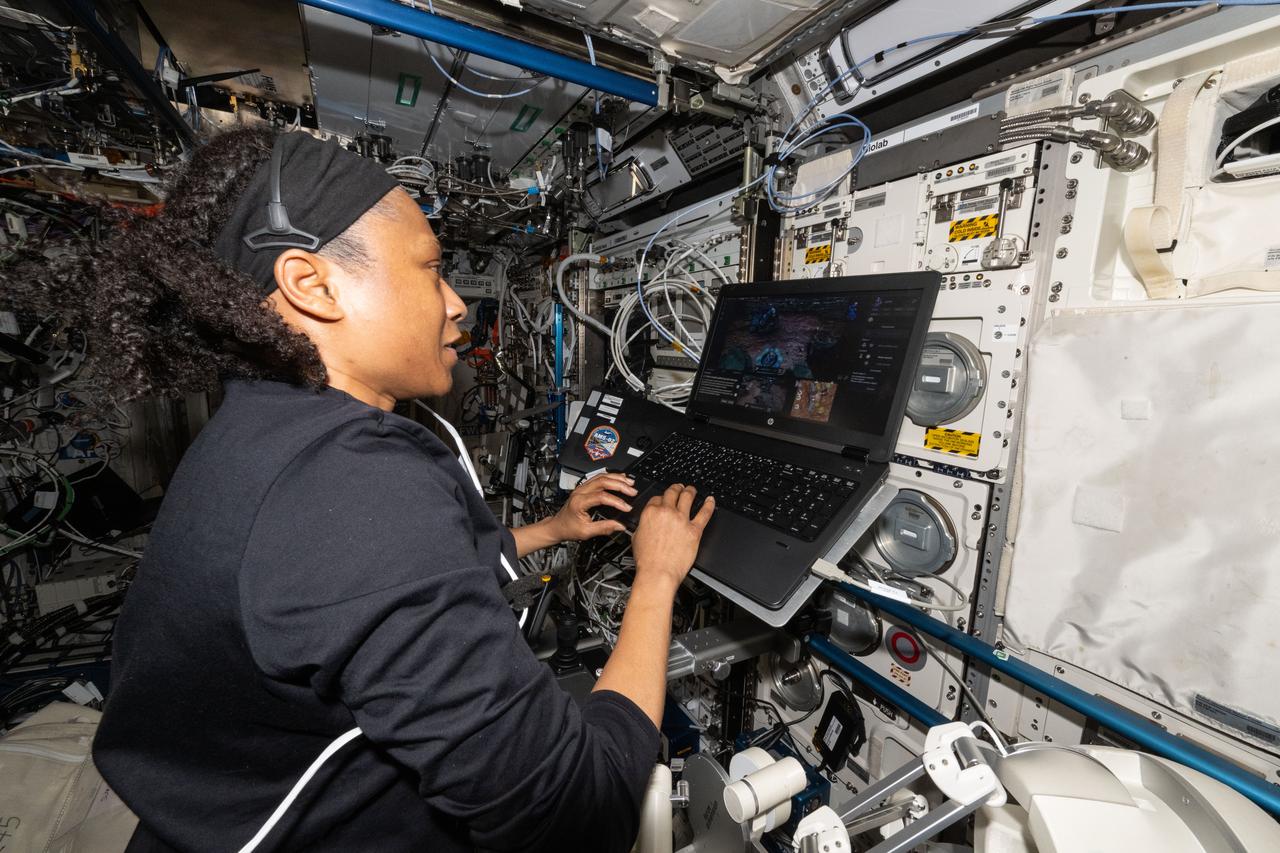 iss071e318587 (July 10, 2024) --- NASA astronaut and Expedition 71 Flight Engineer Jeanette Epps is pictured inside the International Space Station's Columbus laboratory module. She was exploring ways to control a robot on the ground from a spacecraft. Epps coordinated with robotics engineers on Earth remotely manipulating a robot using a computer while testing its ergonomic features and haptic feedback for conditions such as wind and gravity. Results may inform future exploration missions to the Moon, Mars, and beyond.