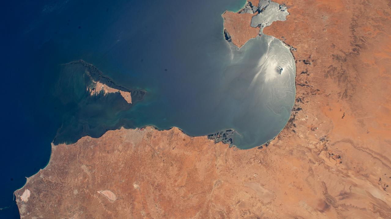 iss071e414023 (Aug. 2, 2024) --- The sun's glint beams off the Gulf of Gabes on the coast of Tunisia with Sharqi Island in the Mediterranean Sea in this photograph taken from the International Space Station as it orbited 262 miles above the African nation.