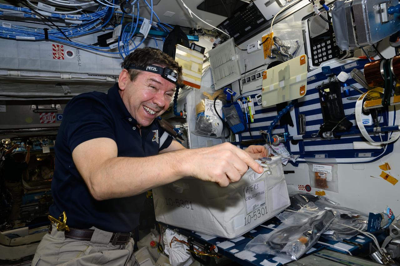 iss071e547719 (Aug. 14, 2024) --- NASA astronaut and Expedition 71 Flight Engineer Mike Barratt transfers cargo bags delivered aboard the Northrop Grumman Cygnus space freighter into the International Space Station's Harmony module.