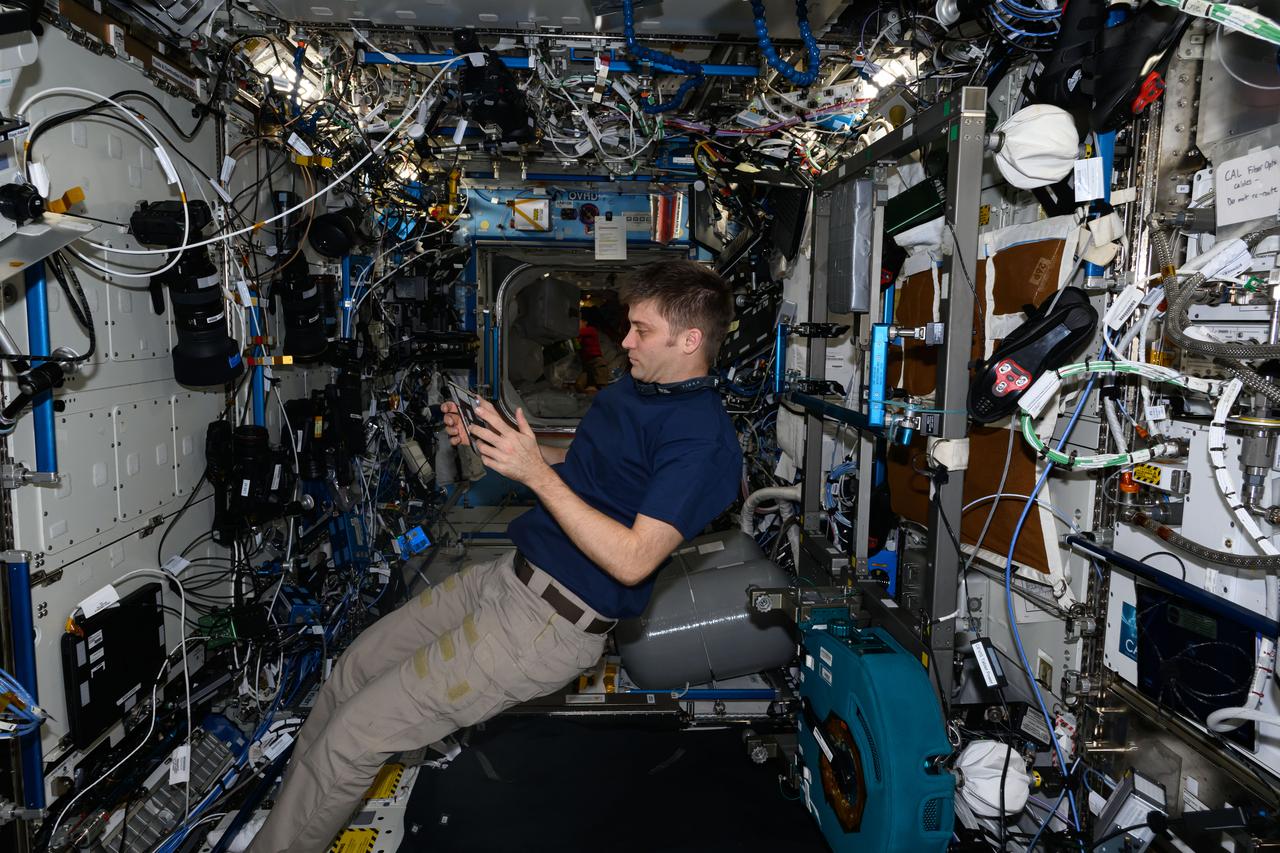 iss071e547731 (Aug. 14, 2024) --- NASA astronaut and Expedition 71 Flight Engineer Matthew Dominick reviews life support maintenance procedures on a computer tablet inside the International Space Station's Destiny laboratory module.