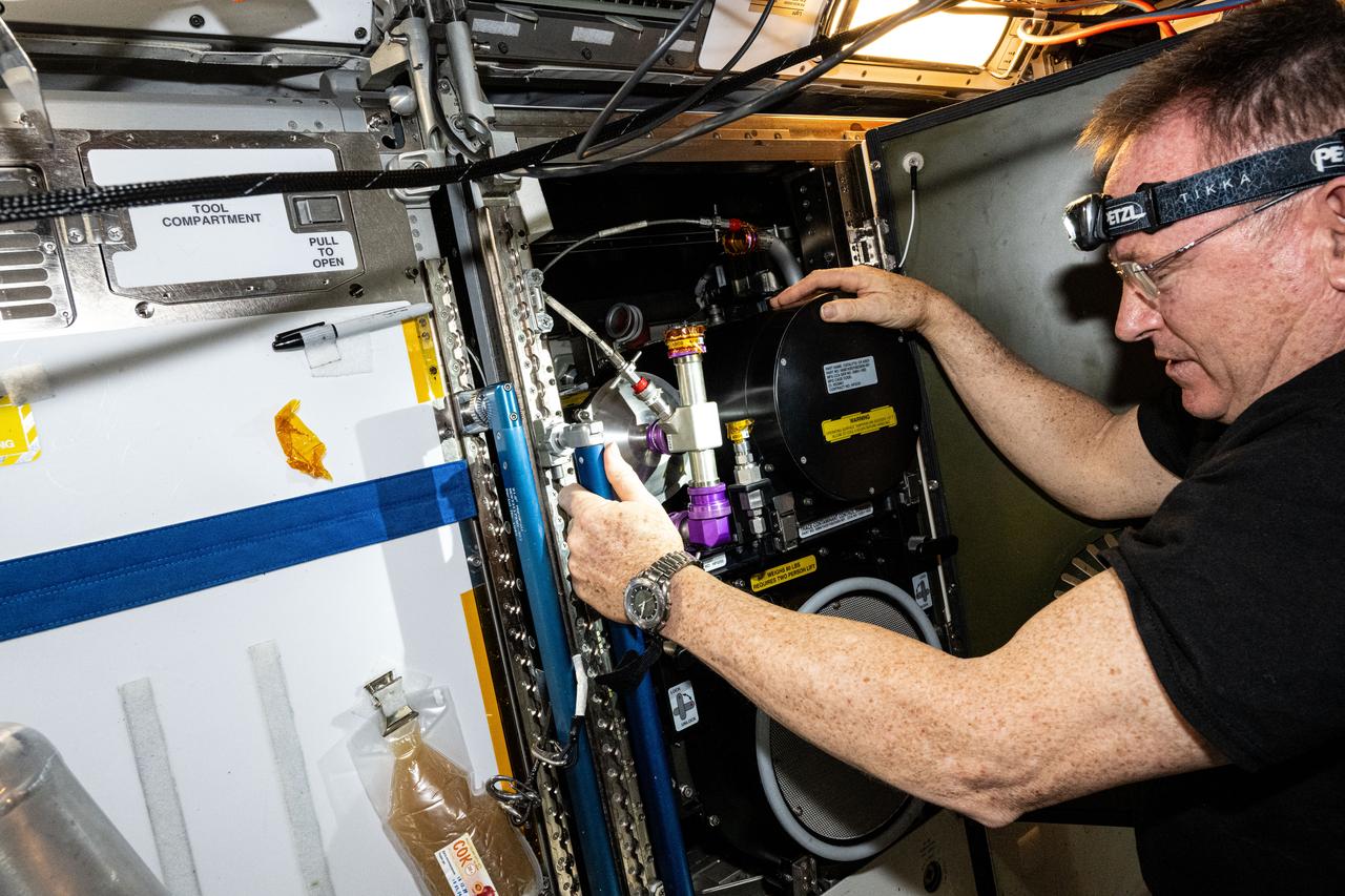 iss071e549503 (Aug. 27, 2024) --- NASA astronaut Butch Wilmore removes the carbon dioxide removal assembly and its components, advanced life support hardware, installed in the Tranquility module's Air Revitalization Rack for maintenance.