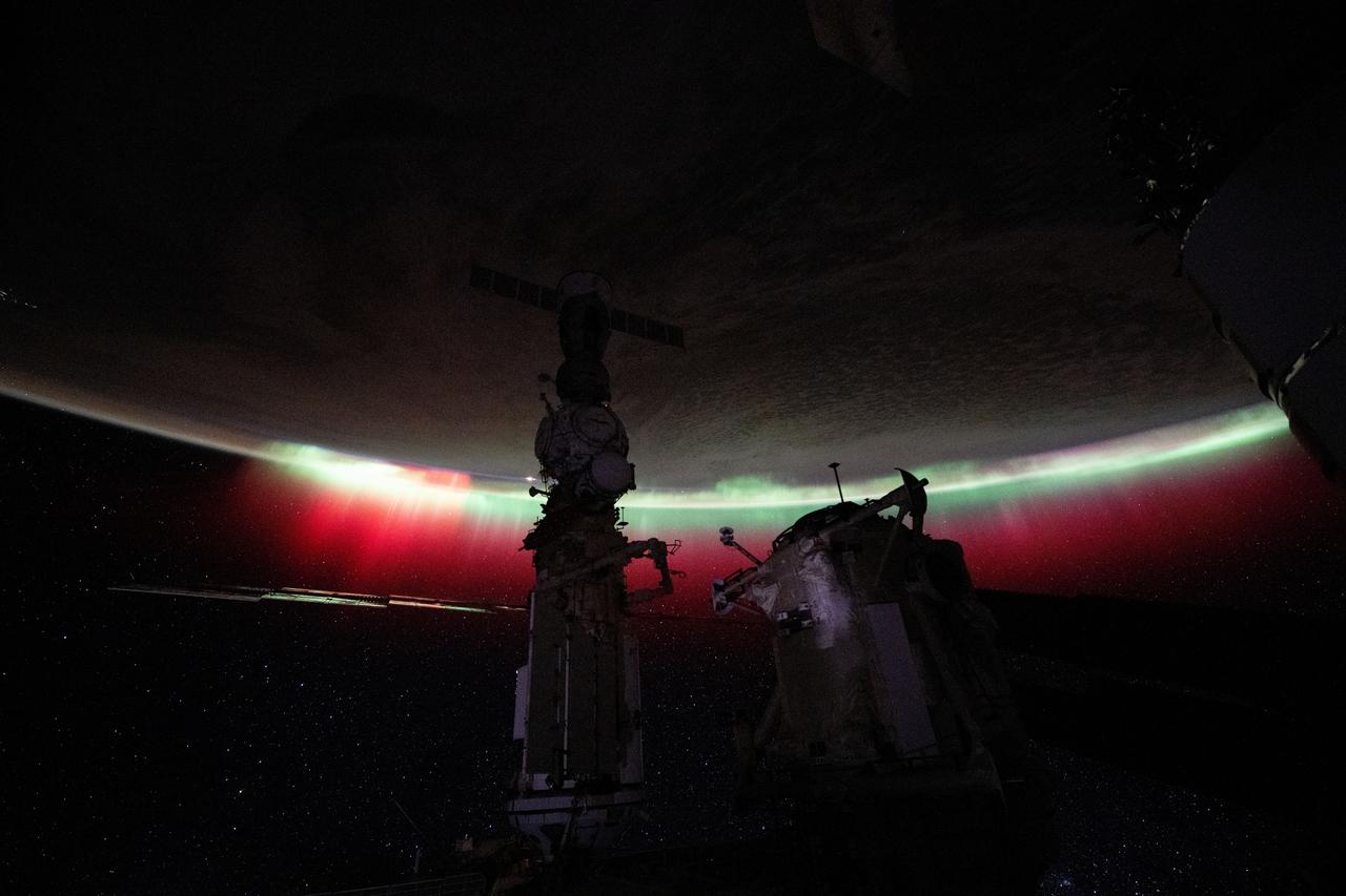 iss071e560367 (Aug. 11, 2024) -- A vibrant green and red aurora shimmers through orbital nighttime as the International Space Station soared 268 miles above New Zealand.