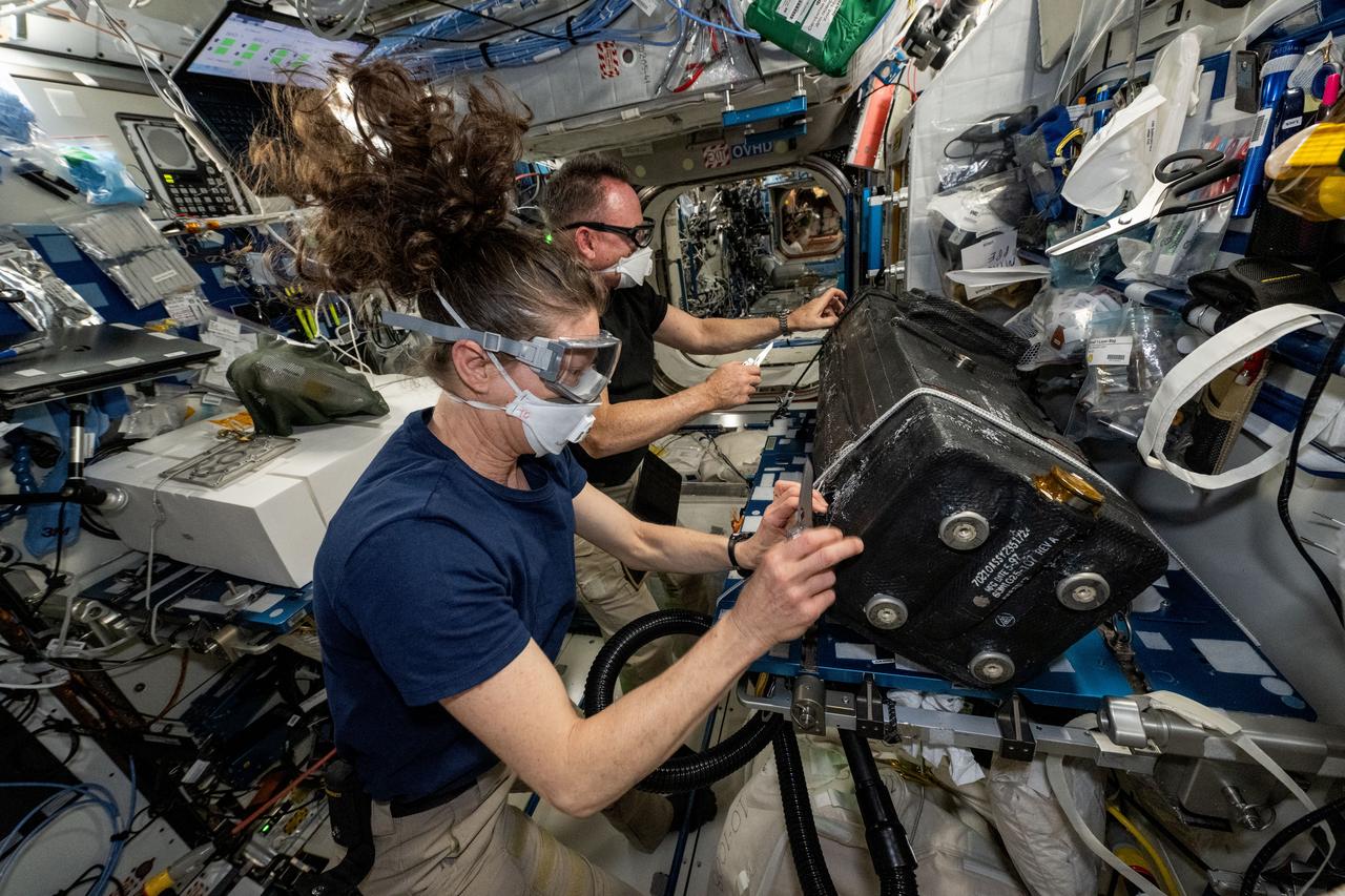 iss071e580478 (Aug. 29, 2024) --- NASA astronauts Tracy C. Dyson (foreground) and Butch Wilmore wear personal protective equipment and clean the inside of the carbon dioxide removal assembly that is part of the International Space Station’s Air Revitalization System located inside the Tranquility module.
