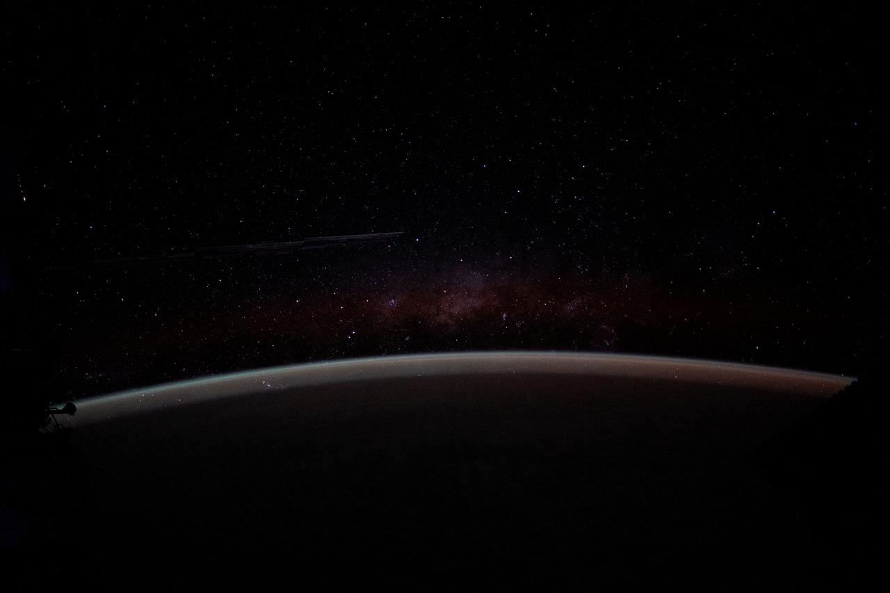 iss071e587371 (Aug. 13, 2024) --- The Earth's airglow blankets the atmosphere with a wispy Milky Way in the background above the horizon in this long-duration photograph taken with a camera programmed for high sensitivity aboard the International Space Station as it orbited 262 miles above the Pacific Ocean off the coast of Peru.