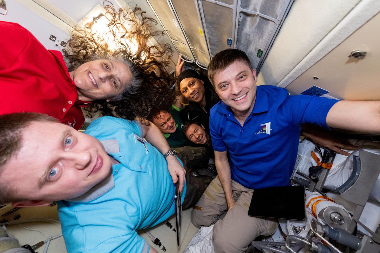 iss071e629760 (Sept. 11, 2024) --- Expedition 71 crew members (clockwise from bottom left) Alexander Grebenkin, from Roscosmos, and NASA astronauts Suni Williams, Jeanette Epps, Matthew Dominick, Mike Barratt, and Butch Wilmore, pose for a portrait inside the International Space Station's Rassvet module.