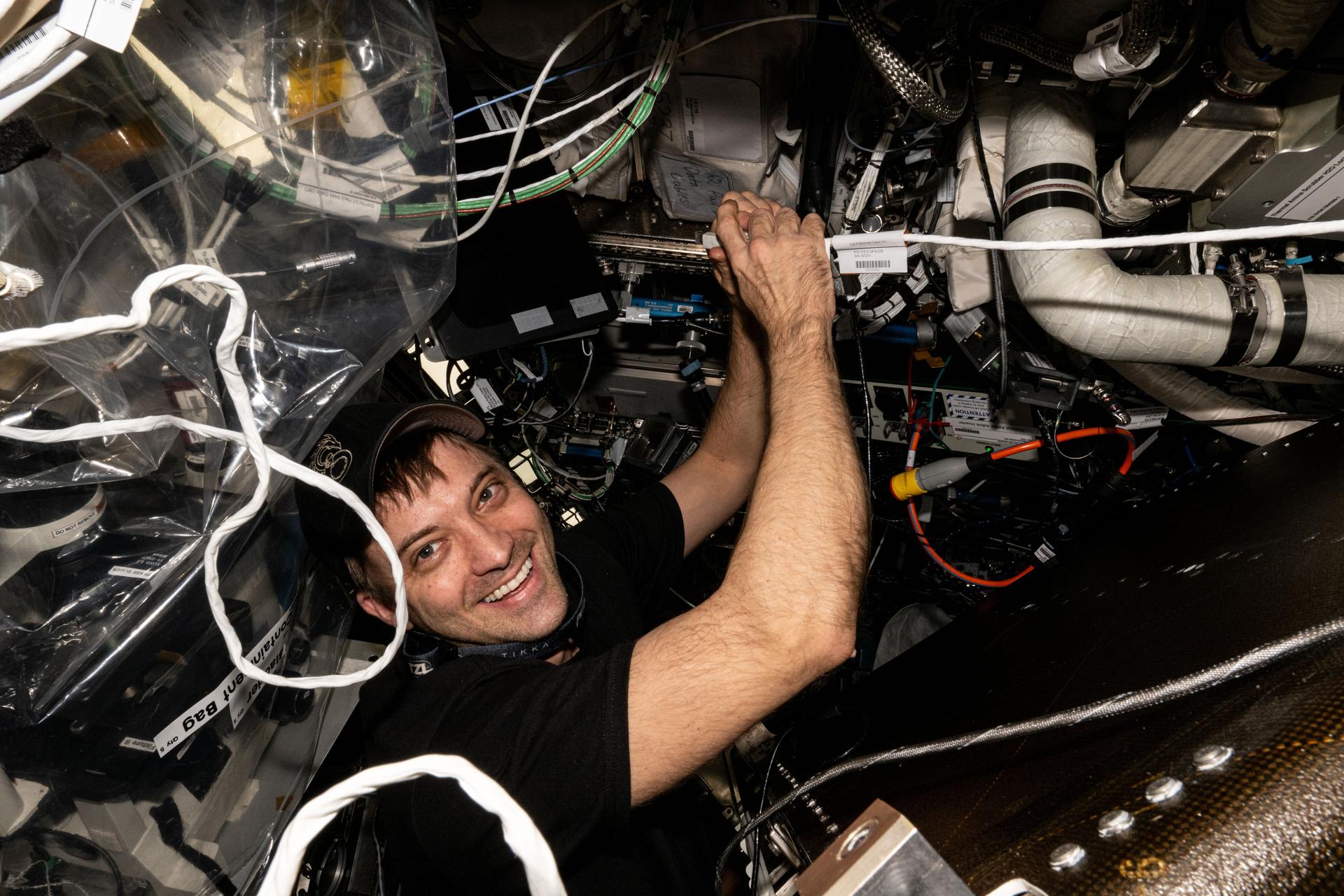 NASA astronaut and Expedition 71 Flight Engineer Matthew Dominick works on an oxygen genarator and prepares the advanced life support device for hardware replacements aboard the International Space Station's Destiny laboratory module.