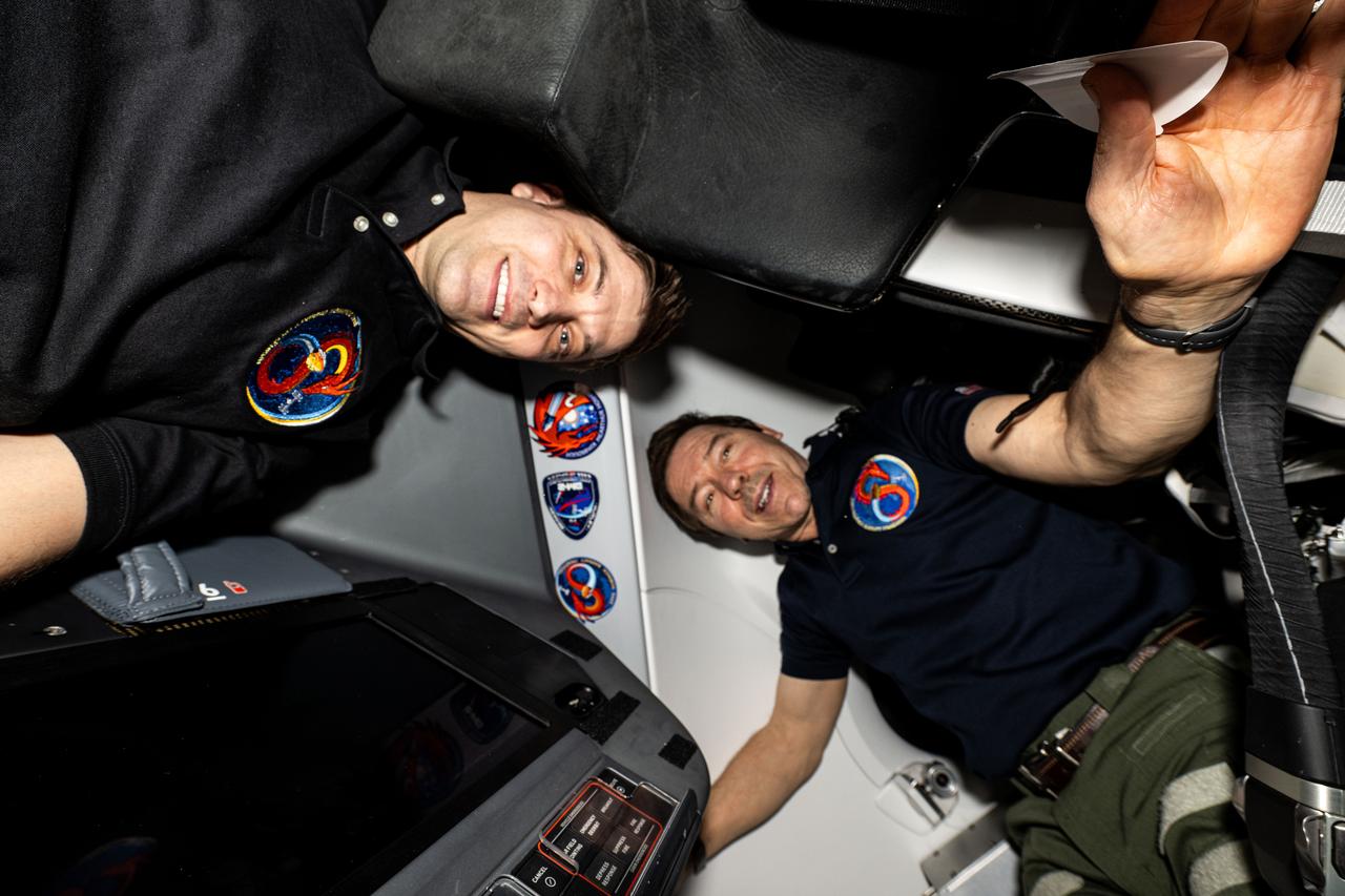 iss072e005790 (Sept. 28, 2024) --- Expedition 72 Flight Engineers (from left) Matthew Dominick and Mike Barratt, both NASA astronauts, pose for a portrait inside the SpaceX Dragon Endeavour spacecraft docked to the Harmony module's space-facing port on the International Space Station. Dominick and Barratt appear next to their mission's insignia, SpaceX Crew-8, alongside the insignias of four other missions that have launched to space aboard Dragon Endeavour.