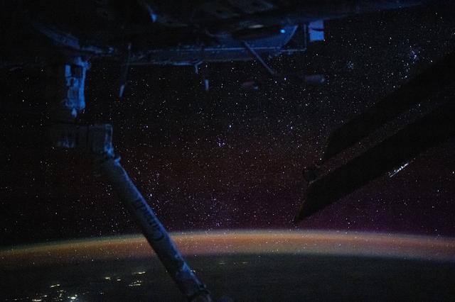 NASA image: The atmospheric glow blankets Earth beneath a sparkling field of stars