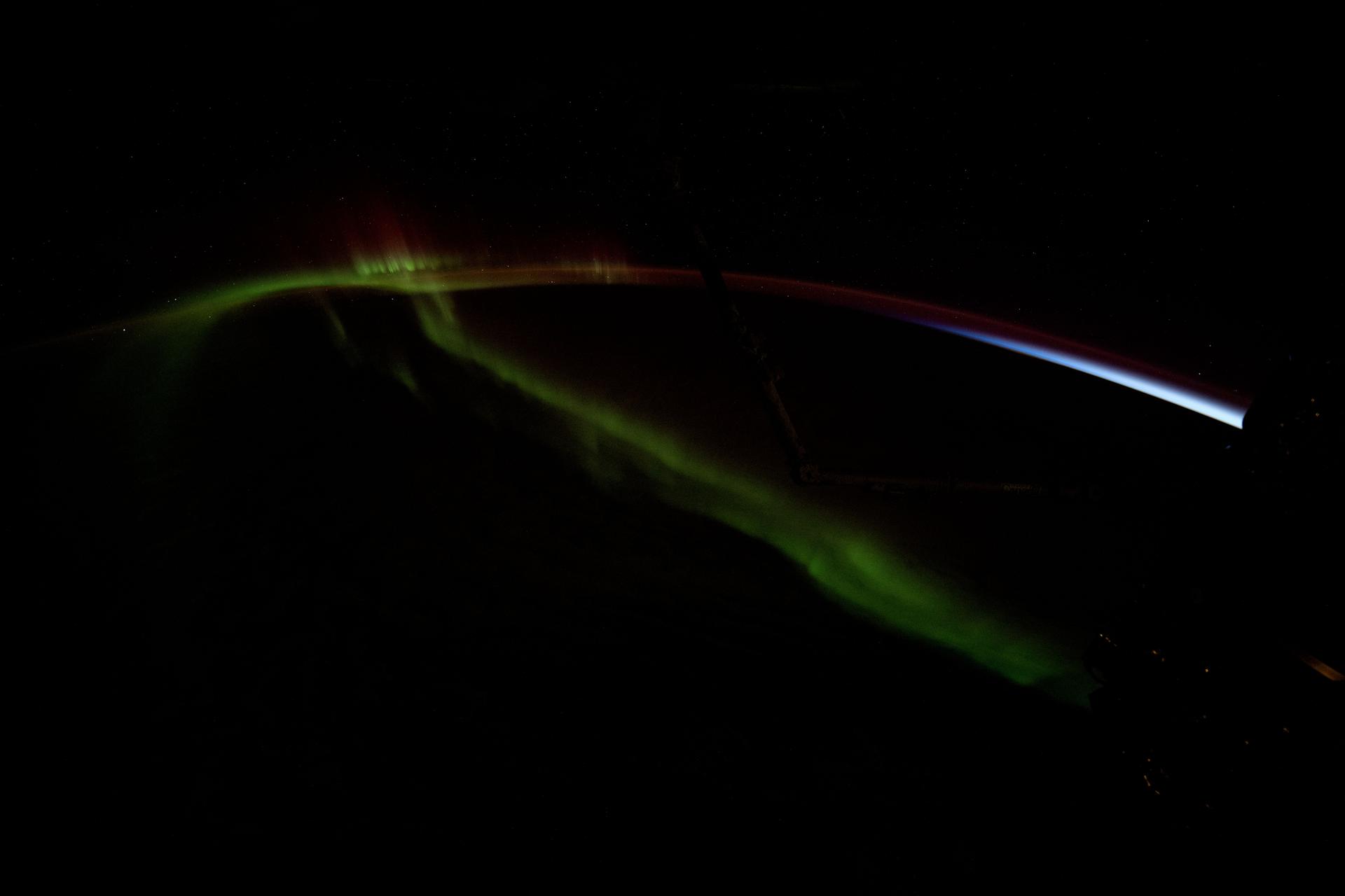 A wispy aurora australis streams over the Earth as the International Space Station soared 274 miles above the Indian Ocean into an orbital sunset southwest of Perth, Australia.