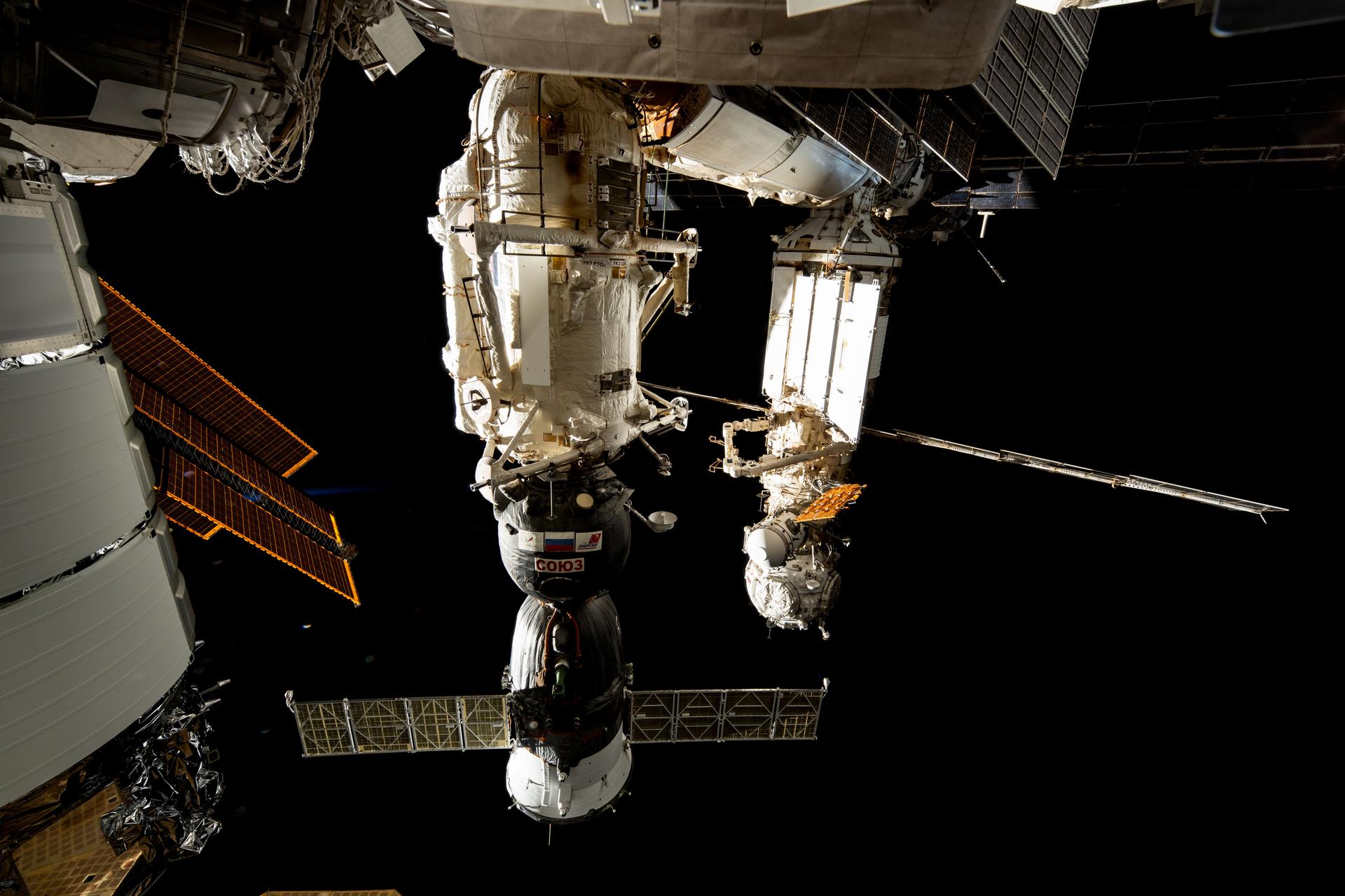 The Soyuz MS-26 crew ship (foreground) from Roscosmos is pictured docked to the International Space Station's Rassvet module. In the background, the Prichal docking module is pictured attached to the Nauka science module with the European robotic arm connected to it.