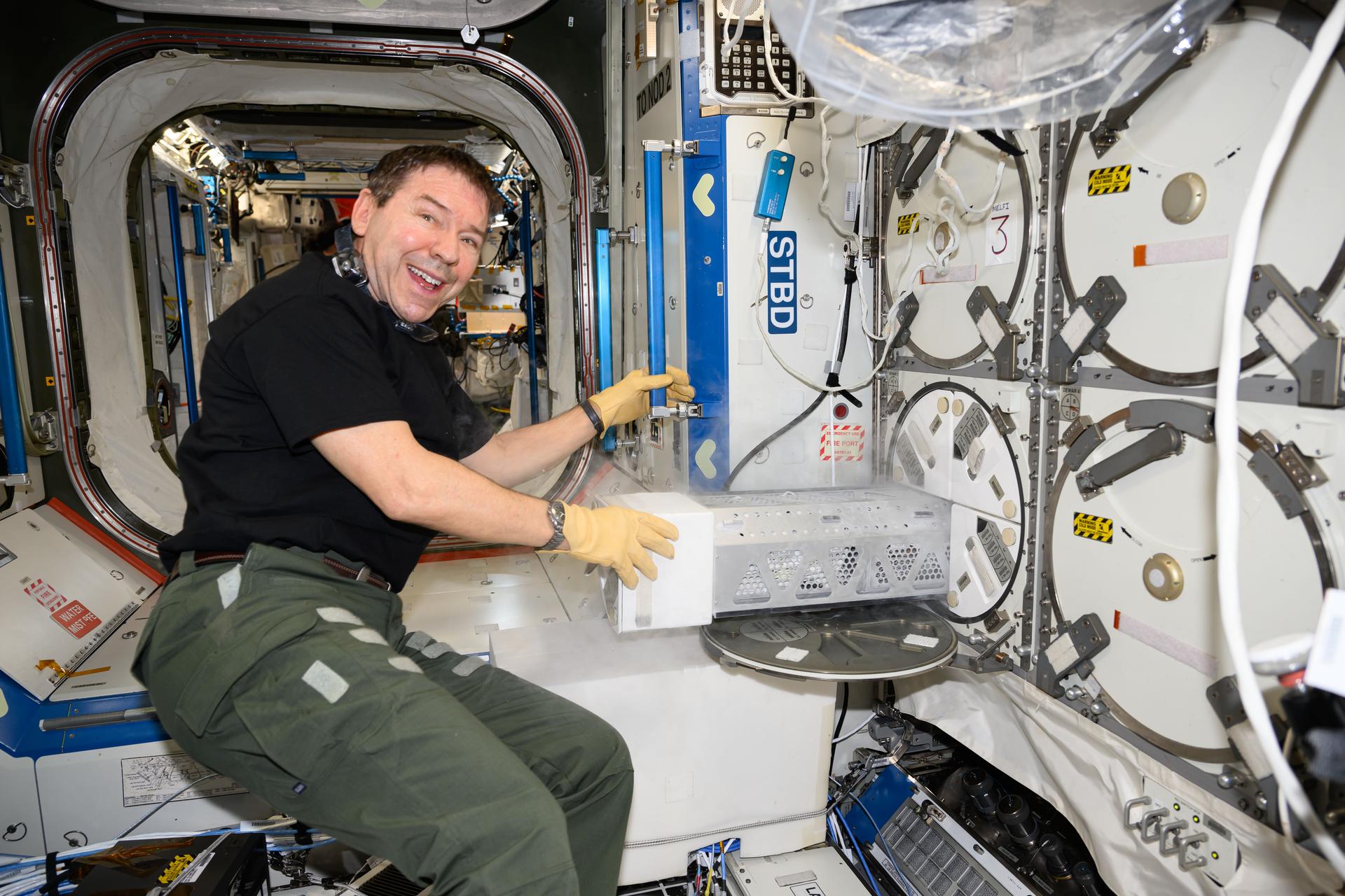 NASA astronaut and Expedition 72 Flight Engineer Mike Barratt stows research samples in a science freezer, also known as the Minus Eighty-Degree Laboratory Freezer for ISS (MELFI). MELFI can preserve biological samples such as blood, microbes, plants, and more for retrieval and later analysis.
