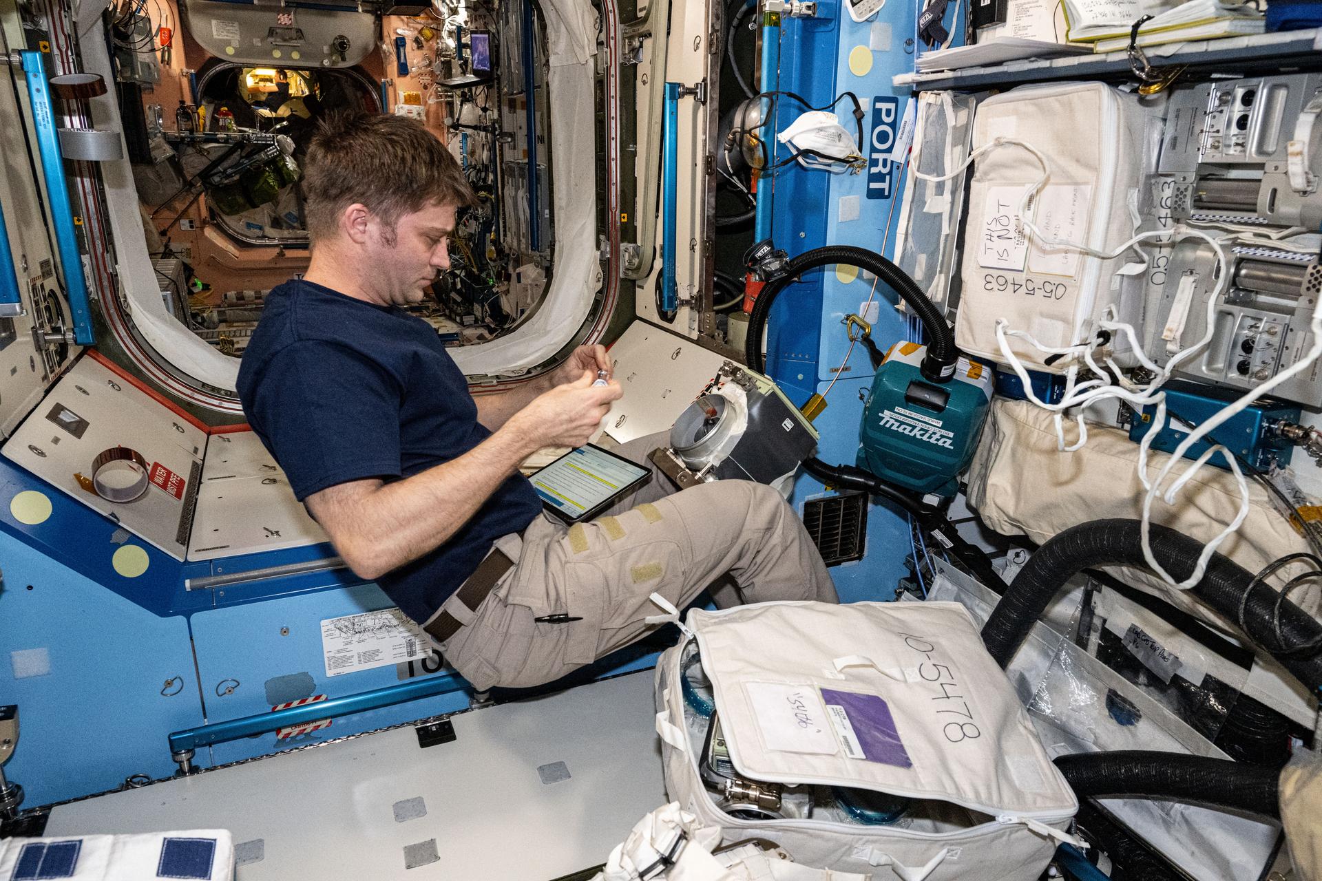 NASA astronaut and Expedition 72 Flight Engineer Matthew Dominick removes and replaces ventilation system components inside the International Space Station's Destiny laboratory module.