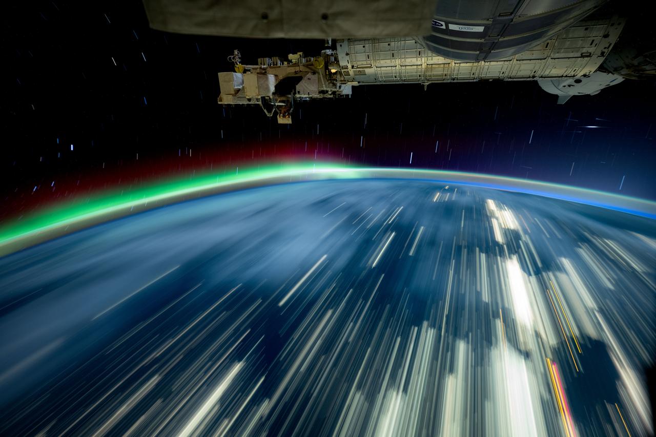 iss072e097446 (Oct. 24, 2024) -- As the International Space Station soared 257 miles above Lake Michigan, NASA astronaut and Expedition 72 Flight Engineer Don Pettit captured this long-exposure photograph of city lights streaking across Earth while a green and red aurora moved through the atmosphere.