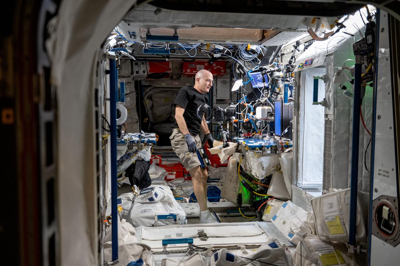iss072e098100 (Oct. 23, 2024) -- NASA astronaut and Expedition 72 Flight Engineer Don Pettit is pictured setting up one of his "Science of Opportunity" experiments aboard the International Space Station. For this specific experiment, Pettit grew thin wafers of water ice using the orbiting lab's freezer, and photographed them in front of a white, blank computer screen and polarizing filter to display the colorful fragments of ice crystals.