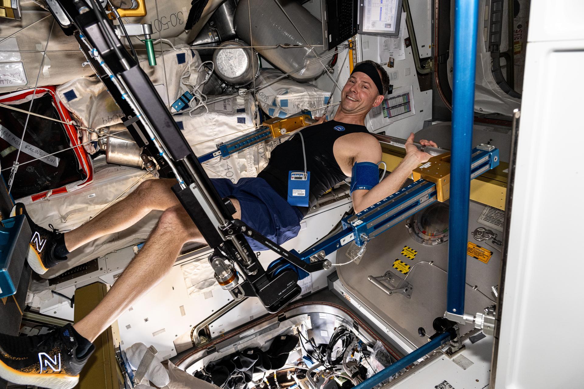 NASA astronaut and Expedition 72 Flight Engineer Nick Hague exercises on the advanced resistive exercise device (ARED) aboard the International Space Station's Tranquility module. The ARED mimics the inertial forces of lifting free weights on Earth to maintain muscle health during long-term space missions. During his exercise session, Hague wore Bio-Monitor, a garment and headband set outfitted with sensors to collect physiological data and minimally interfere with space station life. Hague wore the garment 48 hours as part of Vascular Aging, a study that monitors an astronaut’s cardiovascular health in space.