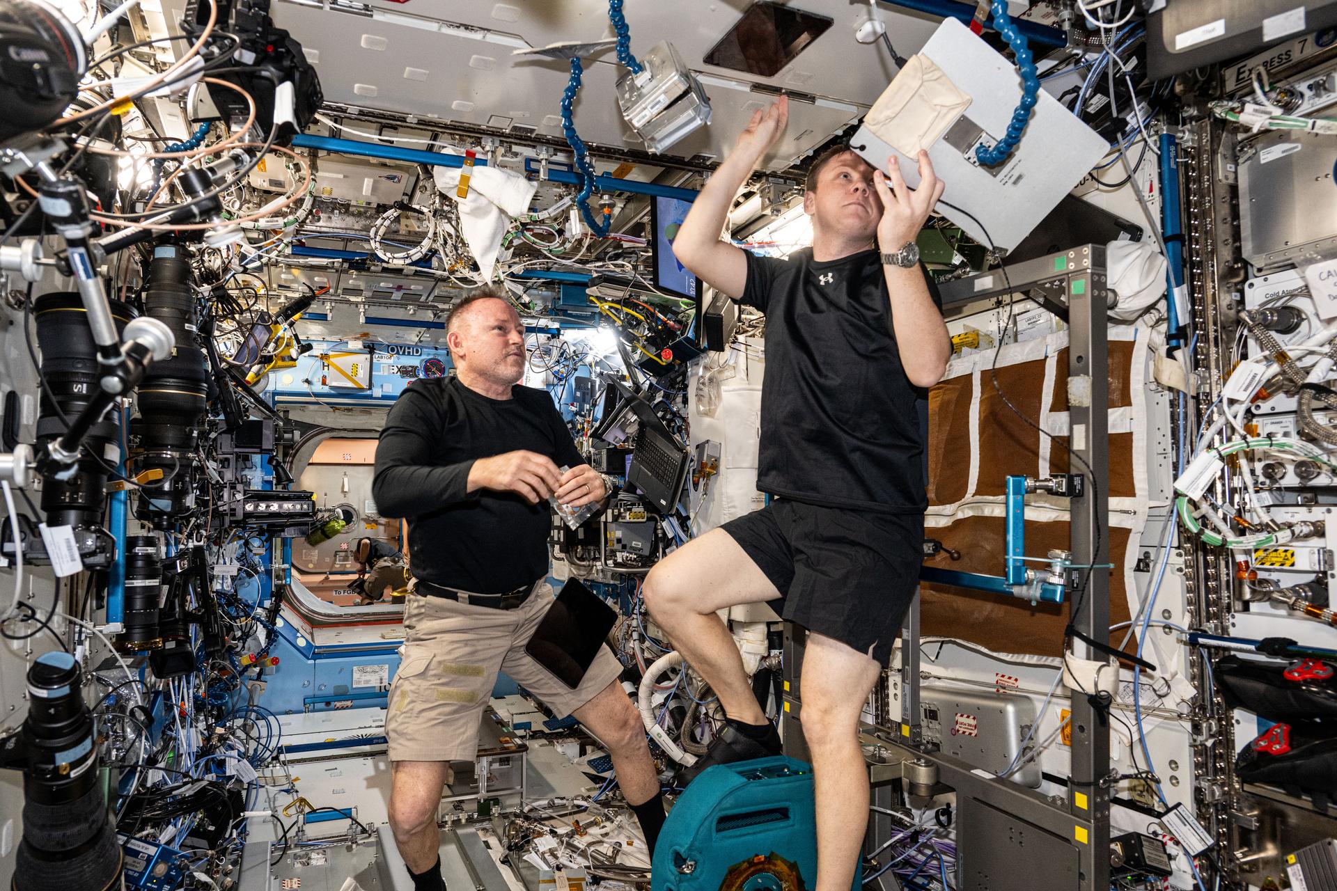 From left, NASA astronaut Butch Wilmore and Roscosmos cosmonaut Aleksandr Gorbunov are pictured aboard the International Space Station's Destiny laboratory module. Wilmore was monitoring Gorbunov as he pedaled on the orbital outpost's exercise cycle, also known as the Cycle Ergometer with Vibration Isolation and Stabilization System (CEVIS).