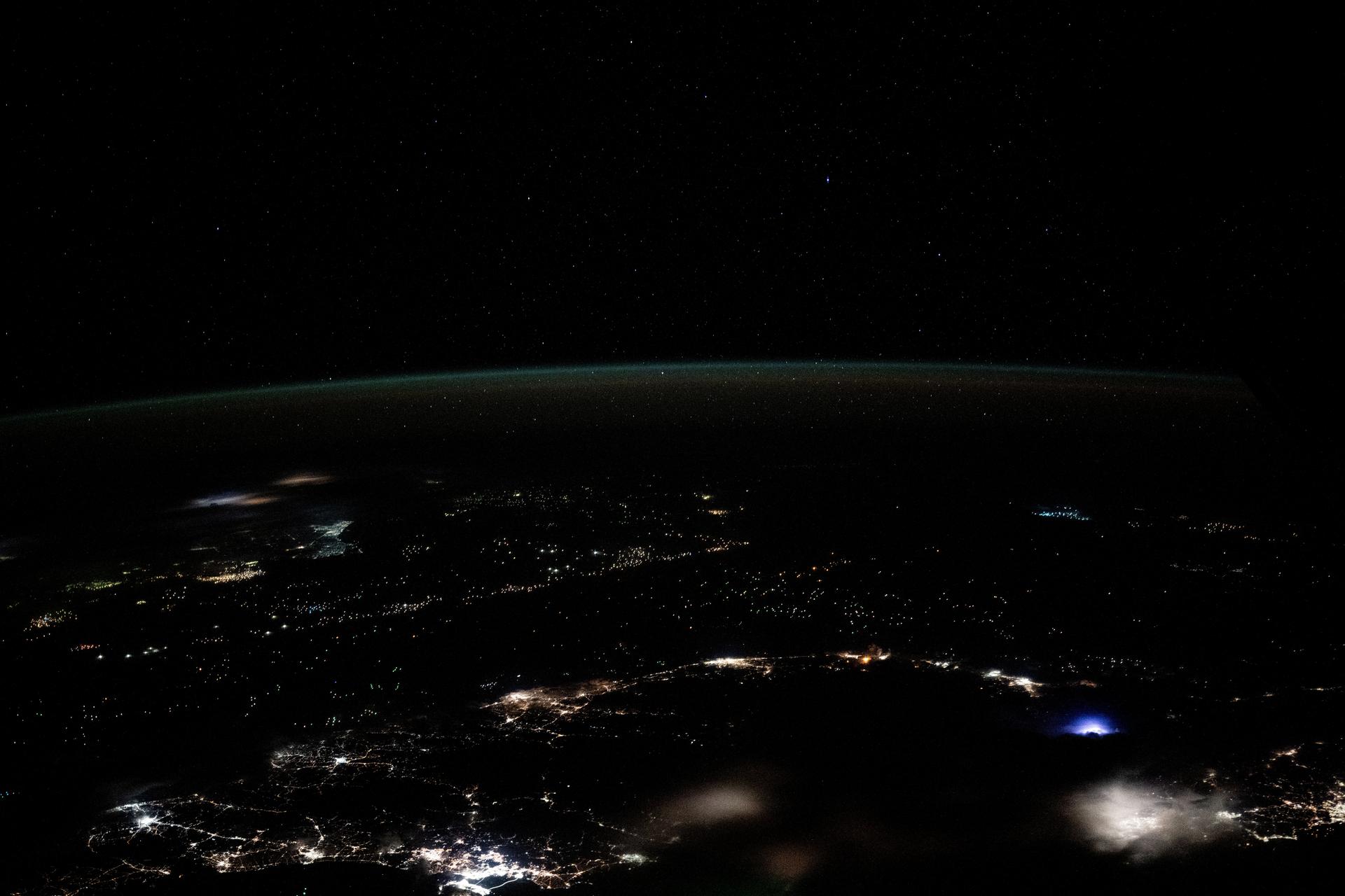 Earth's dim atmopsheric glow blankets the Gulf of Thailand dotted with the lights of fishing boats in this orbital nighttime photograph from the International Space Station as it soared 259 miles above.
