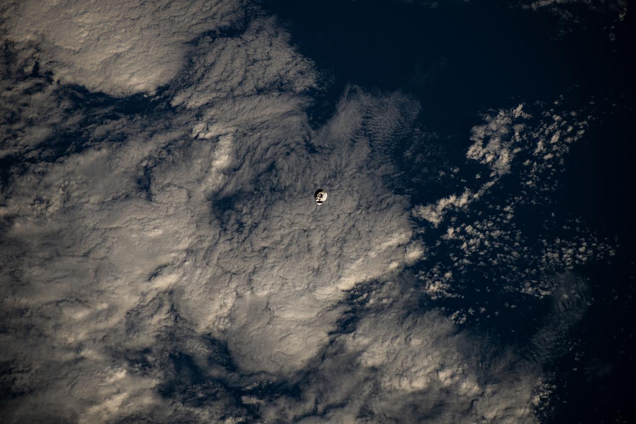 iss072e145206 (Nov. 5, 2024) --- The SpaceX Dragon cargo spacecraft is pictured approaching the International Space Station as both spacecraft were orbiting 255 miles above a cloudy Pacific Ocean southwest of Ecuador's Galápagos Islands.