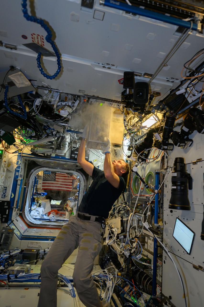iss072e146898 (Nov. 10, 2024) --- NASA astronaut and Expedition 72 Flight Engineer Nick Hague stows samples in a science freezer from the Rhodium Biomanufacturing-03 biotechnology experiment that explores using microorganisms and cell cultures to produce materials and biomolecules on a commercial scale in space.