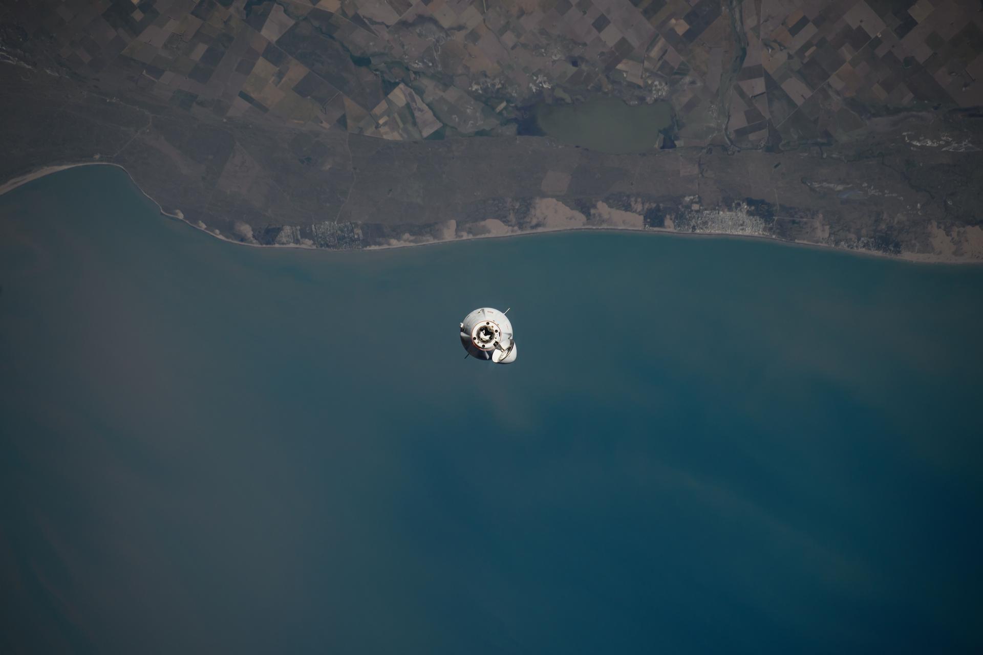 The SpaceX Dragon cargo spacecraft, carrying over 6,000 pounds of science, supplies, and hardware, approaches the International Space Station 265 miles above the Atlantic Ocean off the coast of Uruguay for a docking to its space-facing port on the Harmony module.