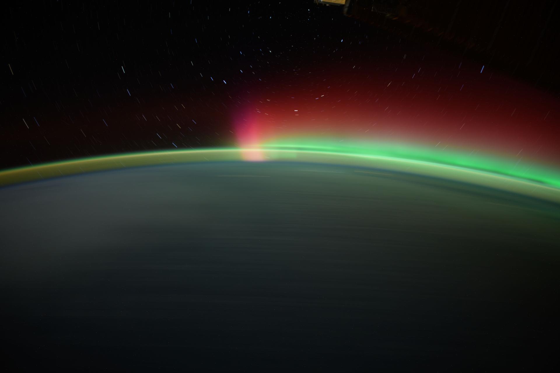 Star trails, an aurora, and Earth's atmospheric glow highlight this long-duration photograph taken from the International Space Station as it orbited 259 miles above the North Pacific Ocean.