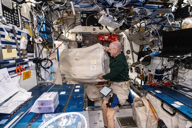 NASA image: Astronaut Don Pettit unpacks and gathers research hardware