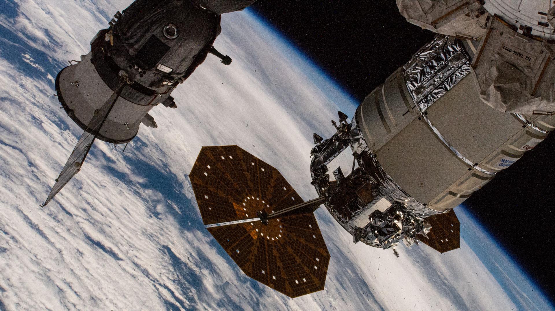 Northrop Grumman's Cygnus cargo spacecraft, with its prominent cymbal-shaped solar arrays, is pictured attached to the Earth-facing port on the International Space Station's Unity module. At left, is a portion of the Soyuz MS-26 crew spacecraft docked to the Rassvet module. The orbital outpost was soaring 260 miles above the Indian Ocean south of South Africa at the time of this photograph.