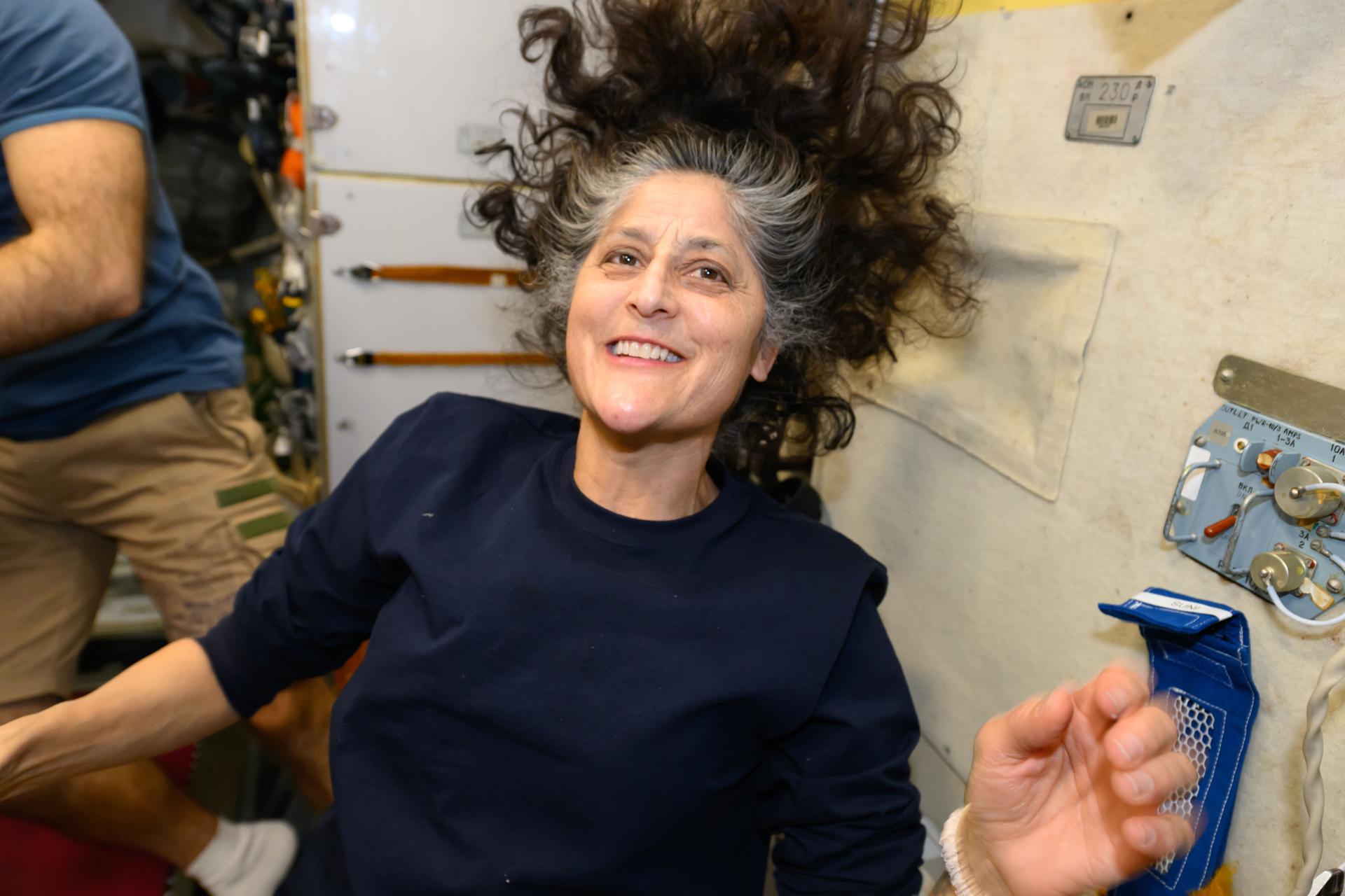 NASA astronaut and Expedition 72 Commander Suni Williams smiles for a portrait inside the International Space Station's Zvezda service module during dinner time.
