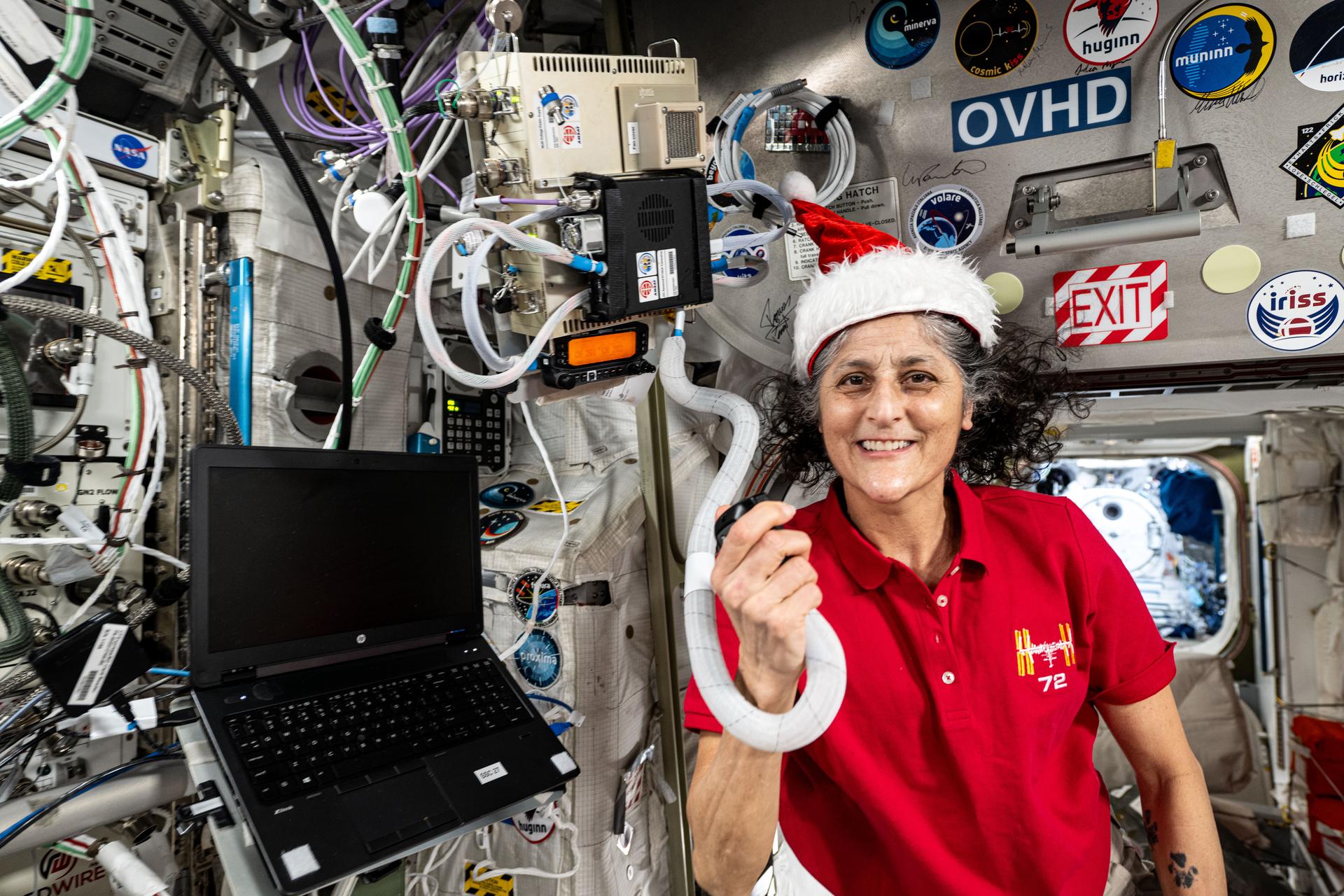 NASA astronaut and Expedition 72 Commander Suni Williams poses for a fun holiday season portrait while speaking on a ham radio inside the International Space Station's Columbus laboratory module.