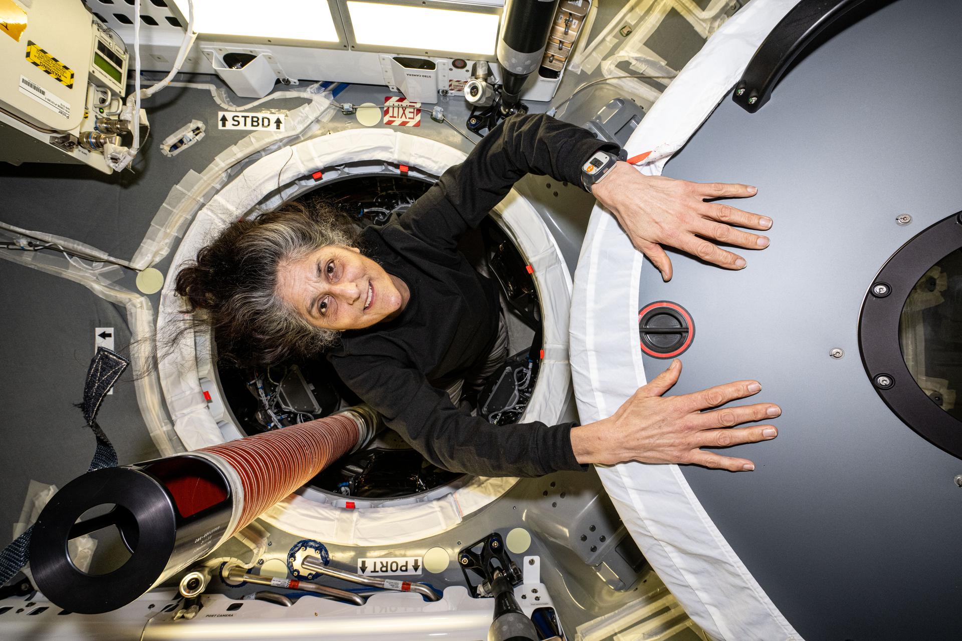 NASA astronaut and Expedition 72 Commander Suni Williams is pictured inside the vestibule between the SpaceX Dragon cargo spacecraft and the forward port on the International Space Station's Harmony module.