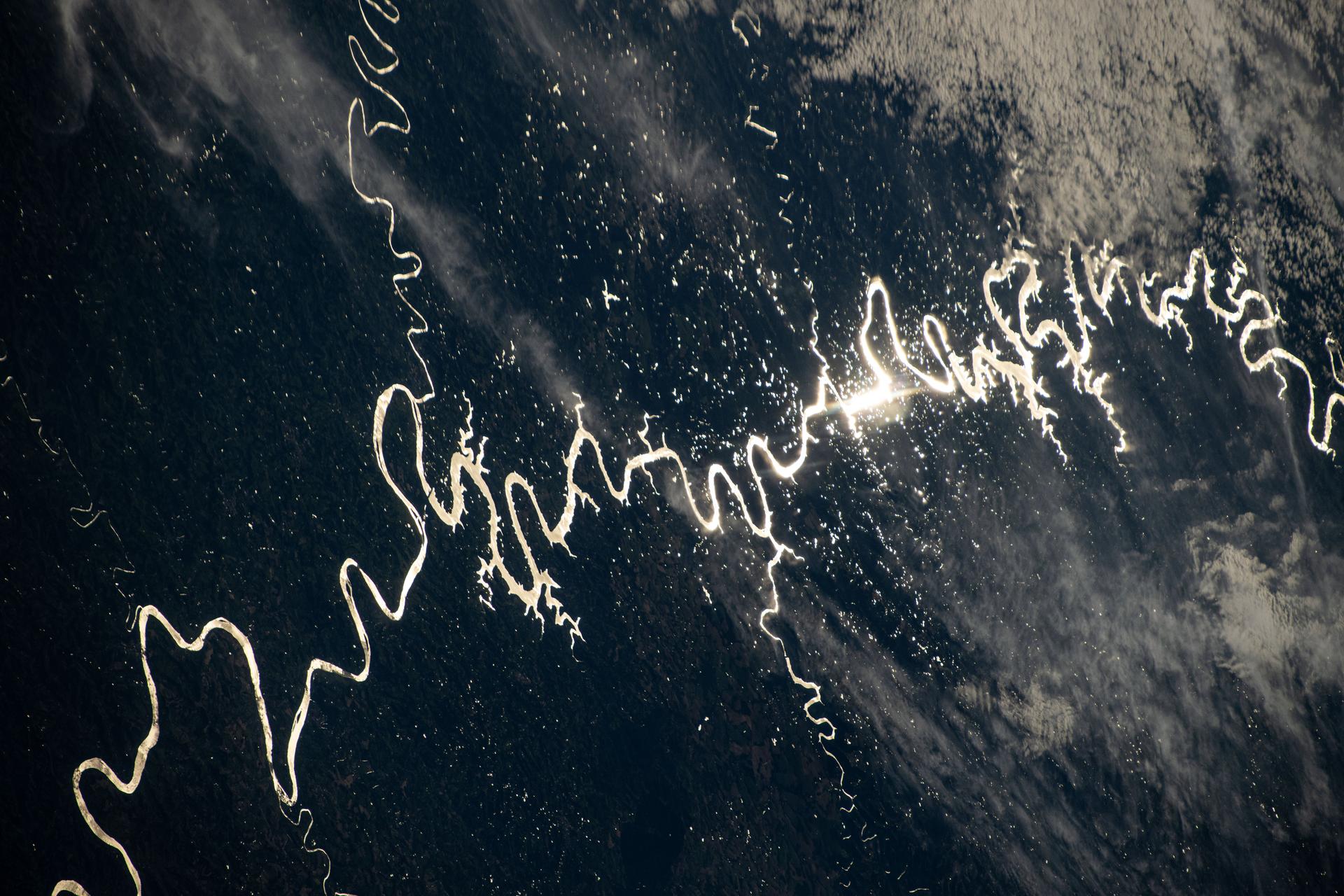 The Sun's glint beams off one of the many rivers that snake throughout South America's fertile, low grasslands region, also known as the Pampas. The International Space Station was orbiting 261 miles above the border of Paraguay and Argentina at the time of this photograph. Credit: NASA/Don Pettit